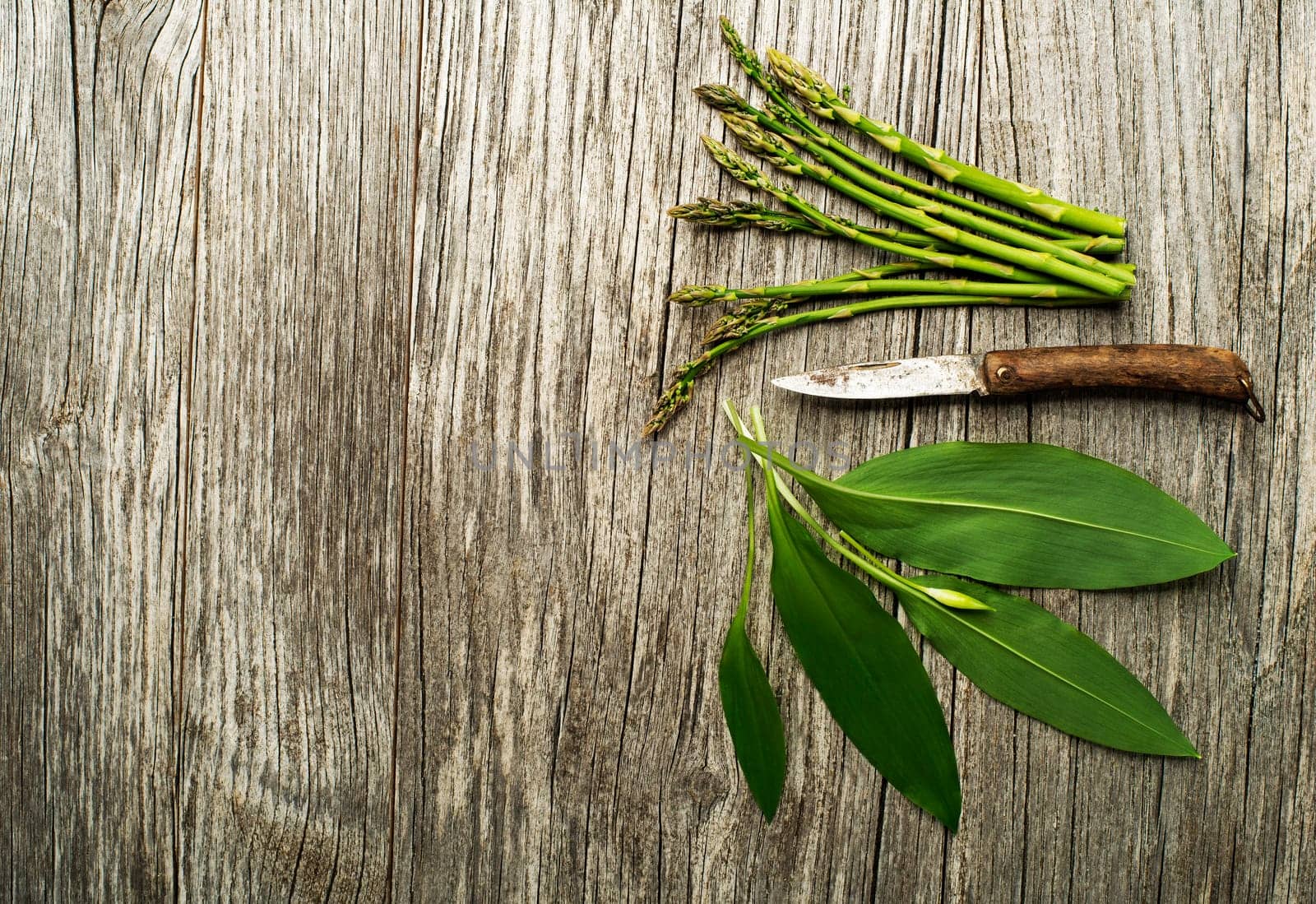Spring food wild garlic and asparagus on wooden background