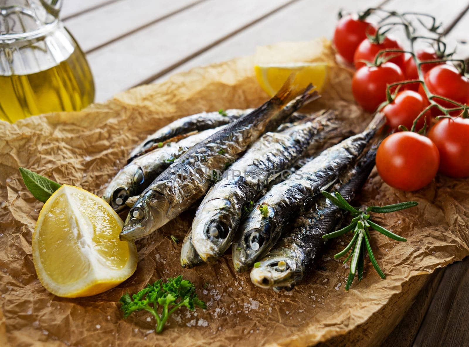 Fried sardines with lemon and salad close up.