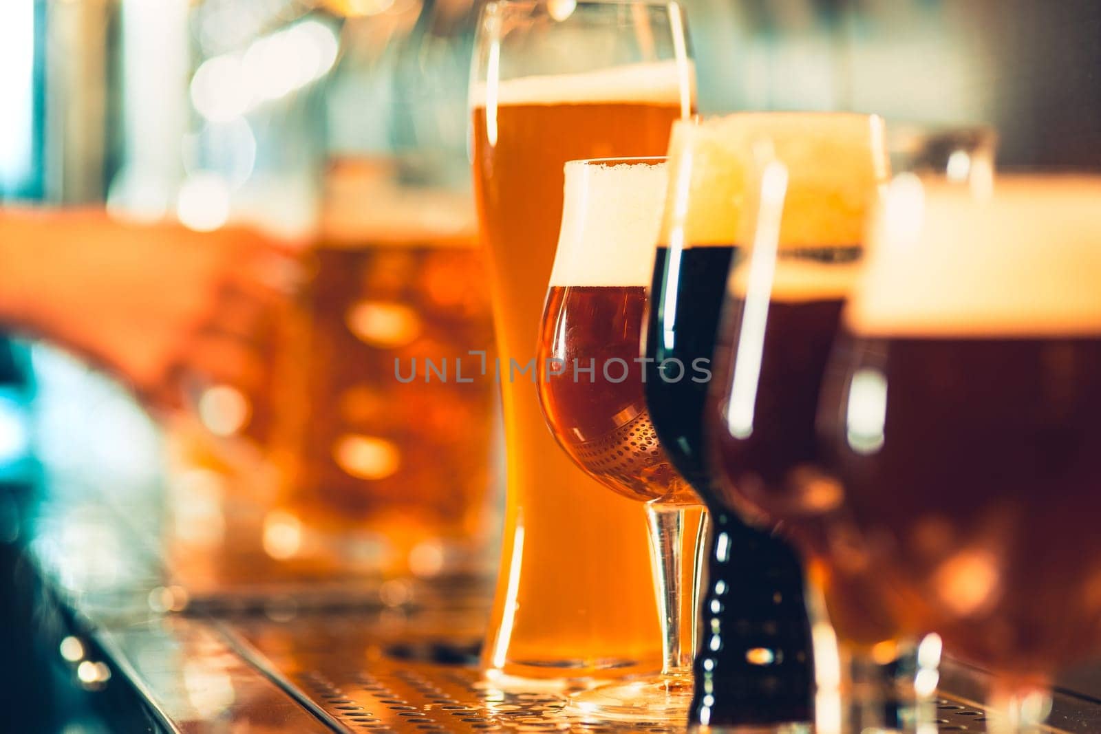 The beer taps in a pub. nobody. Selective focus. Alcohol concept. Vintage style. Beer craft. Bar table. Steel taps. Shiny taps. Glass of beer. Octoberfest concept