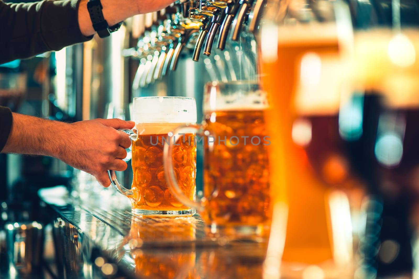 The beer taps in a pub. nobody. Selective focus. Alcohol concept. Vintage style. Beer craft. Bar table. Steel taps. Shiny taps. Glass of beer