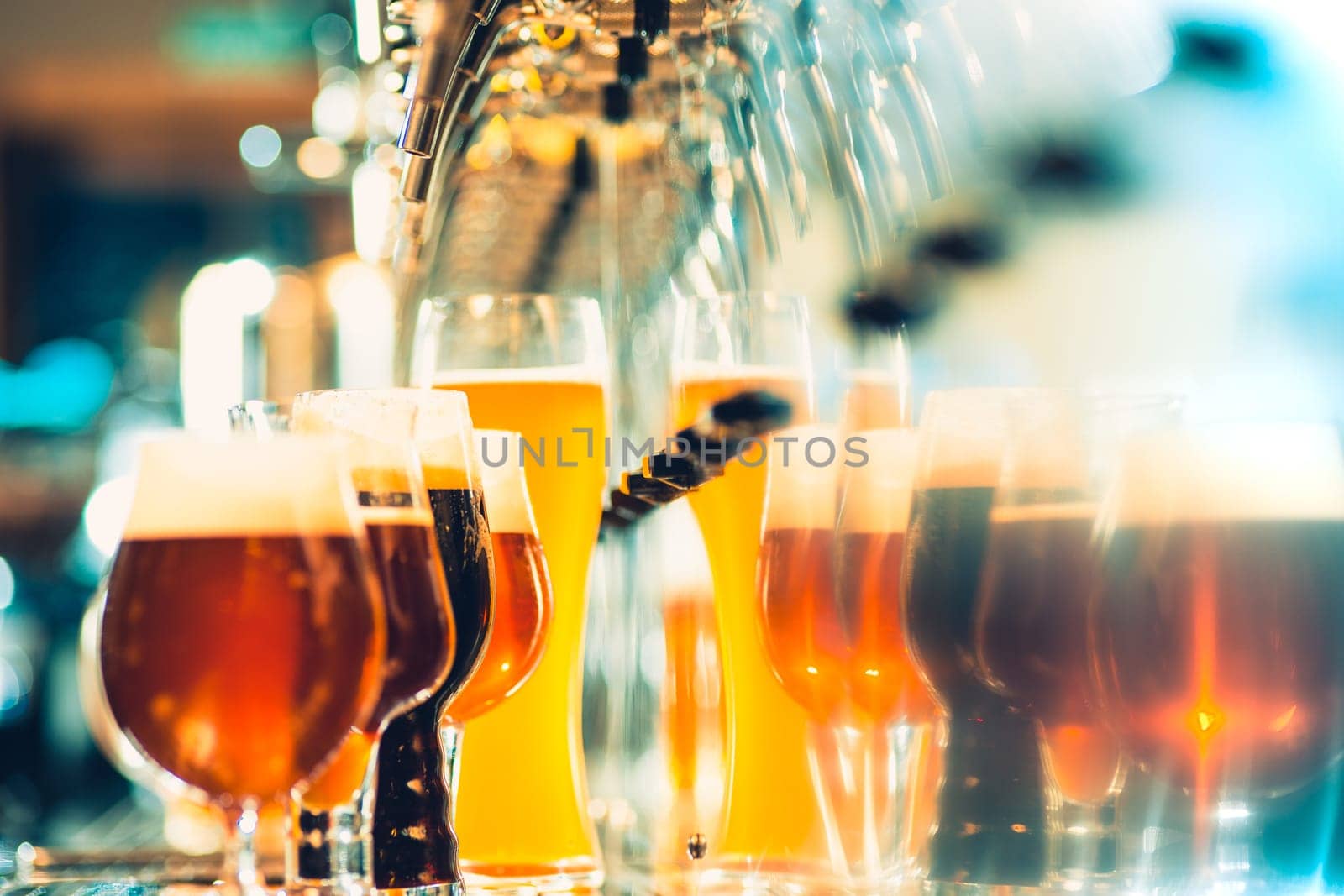The beer taps in a pub. nobody. Selective focus. Alcohol concept. Vintage style. Beer craft. Bar table. Steel taps. Shiny taps. Glass of beer