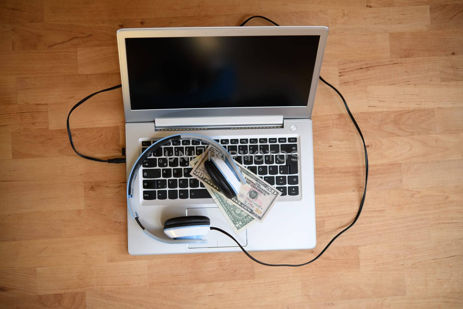 computer keyboard with headphones and dollar bank notes