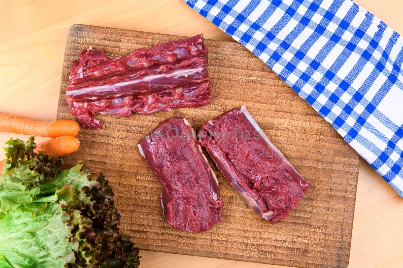saddle of venison on wooden board with big knife