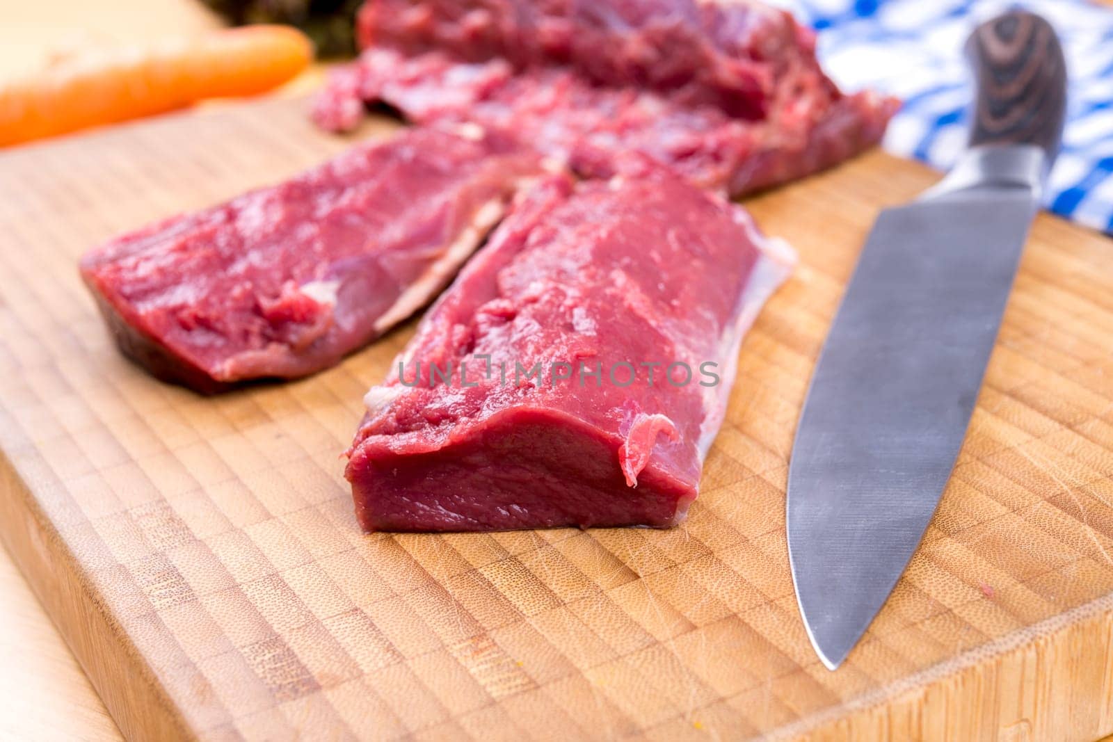 saddle of venison on wooden board with big knife