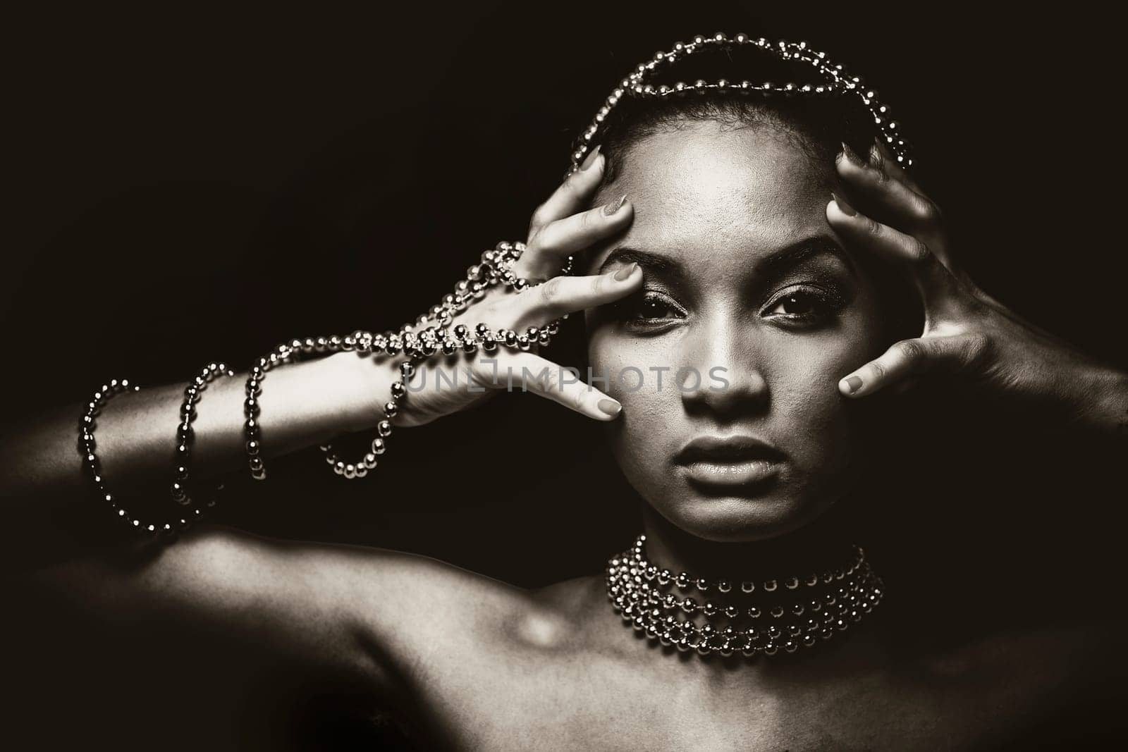 Upscale Indian woman wearing chain jewellery and beautiful makeup. Black and white photo. Mysterious beauty expressions.