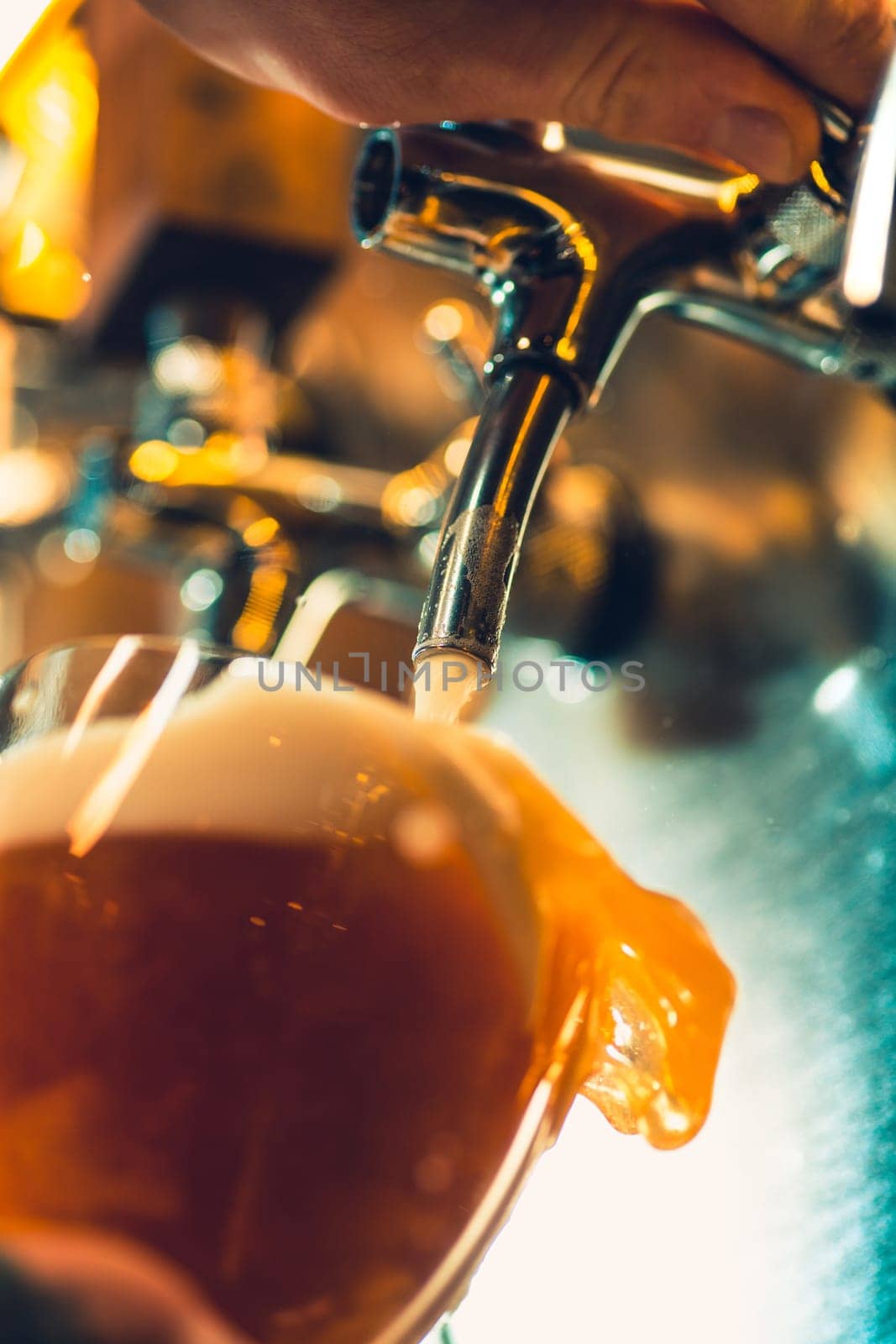 The beer taps in a pub. nobody. Selective focus. Alcohol concept. Vintage style. Beer craft. Bar table. Steel taps. Shiny taps. Glass of beer