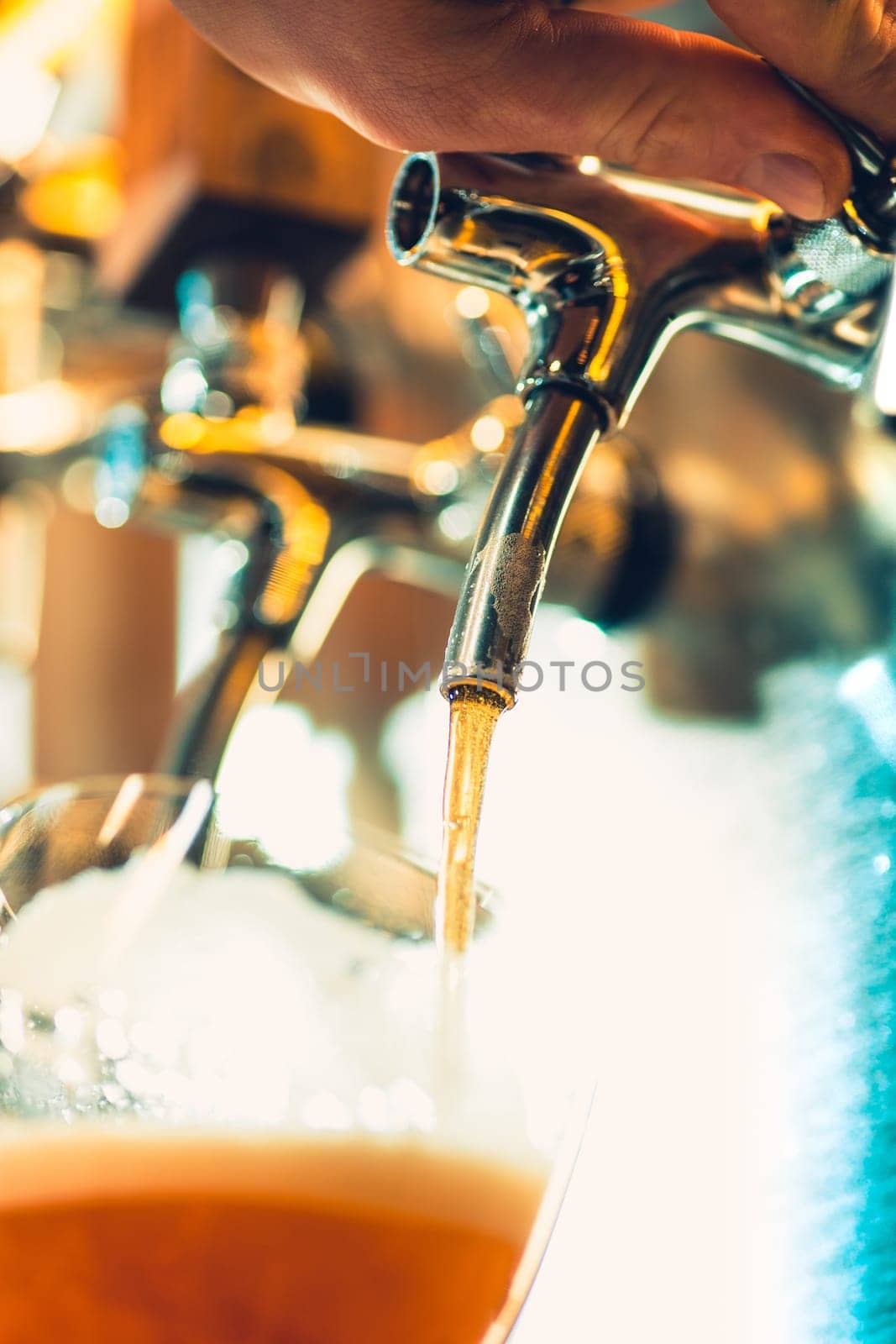 The beer taps in a pub. nobody. Selective focus. Alcohol concept. Vintage style. Beer craft. Bar table. Steel taps. Shiny taps. Glass of beer