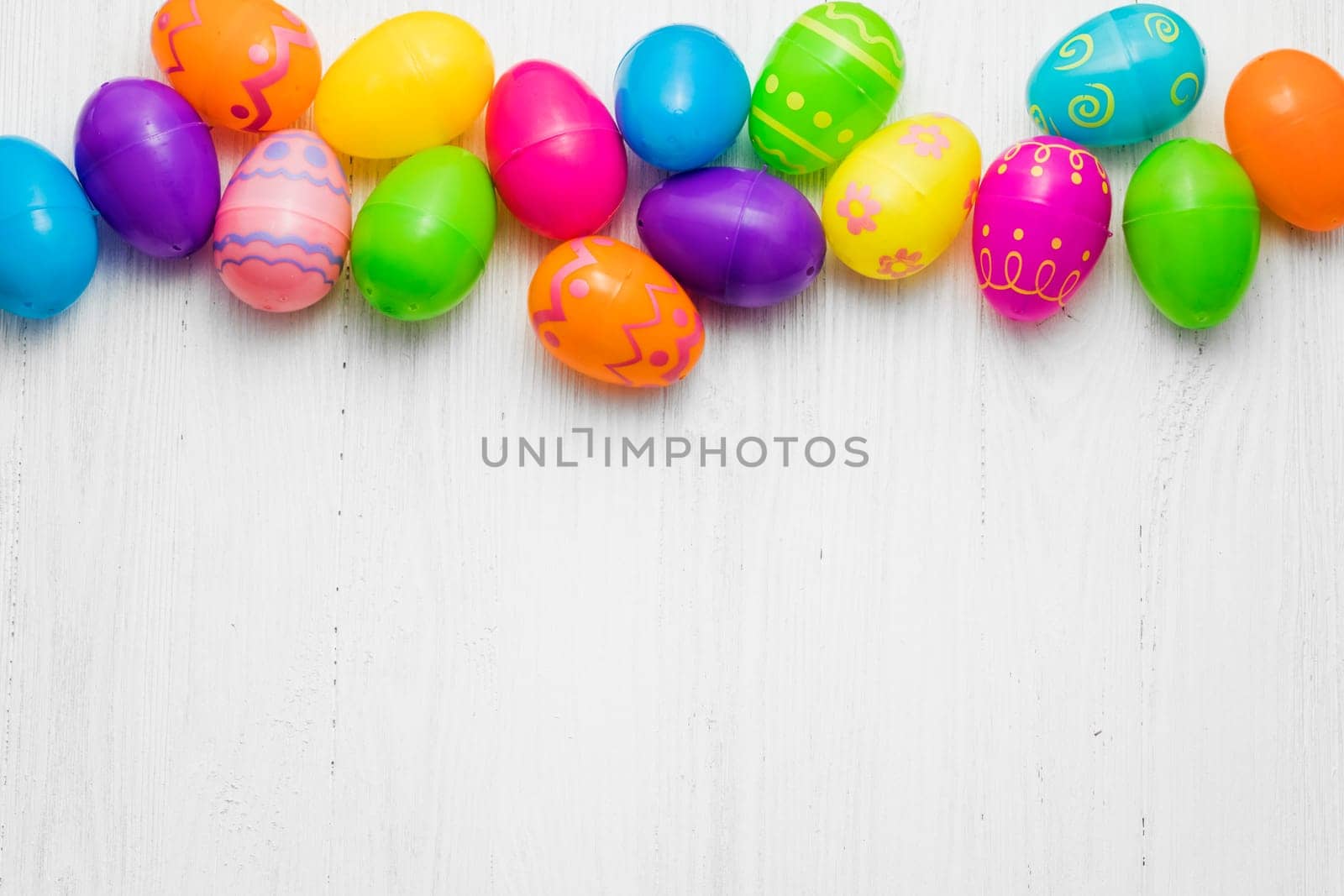 Multi colored Easte eggs on white wooden background