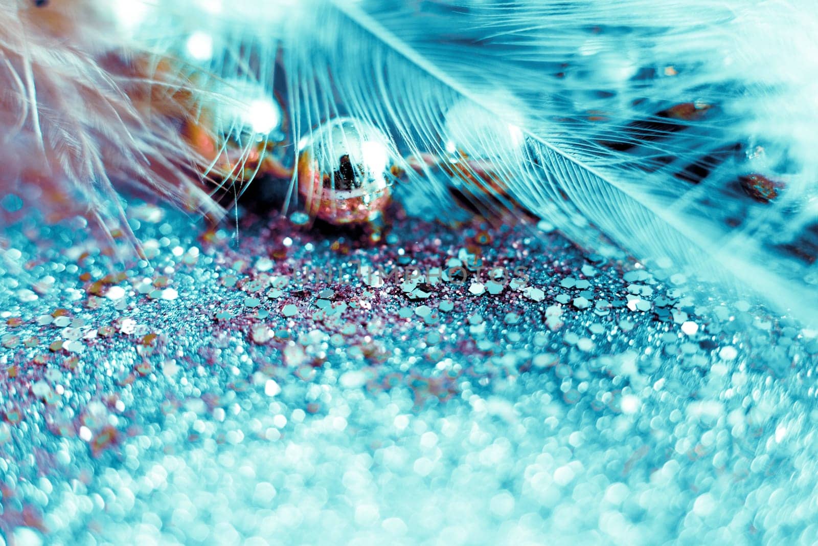 Soft feather with sparkles with artistic bright light and shadows. Soft blurred background of artistic close-up glitter macro image.