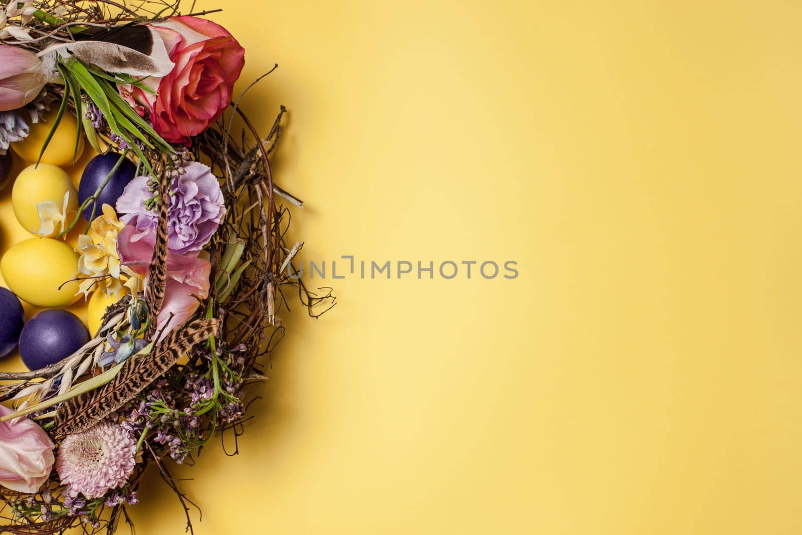 Easter card. Painted Easter eggs in nest on yellow table background. Top view of easter decoration. Happy easter concept. Trendy colors