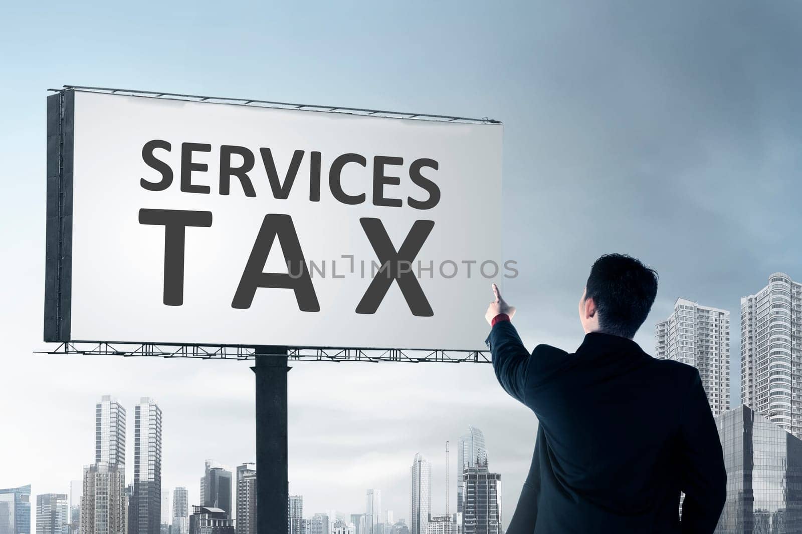 Rear view of businessman pointing at billboard with Services tax sign. Goods and Services Tax concept.
