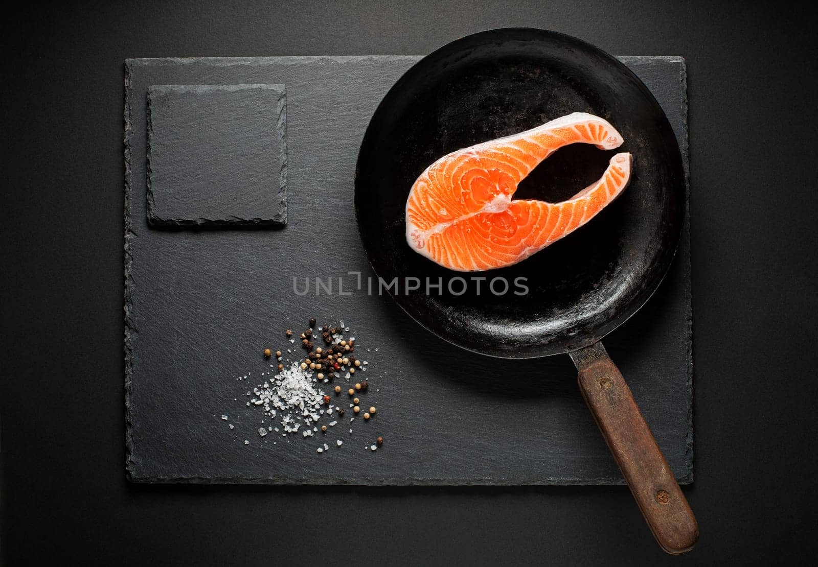 Slice of red salmon fish with spices in pan. Prepare for cooking meal.