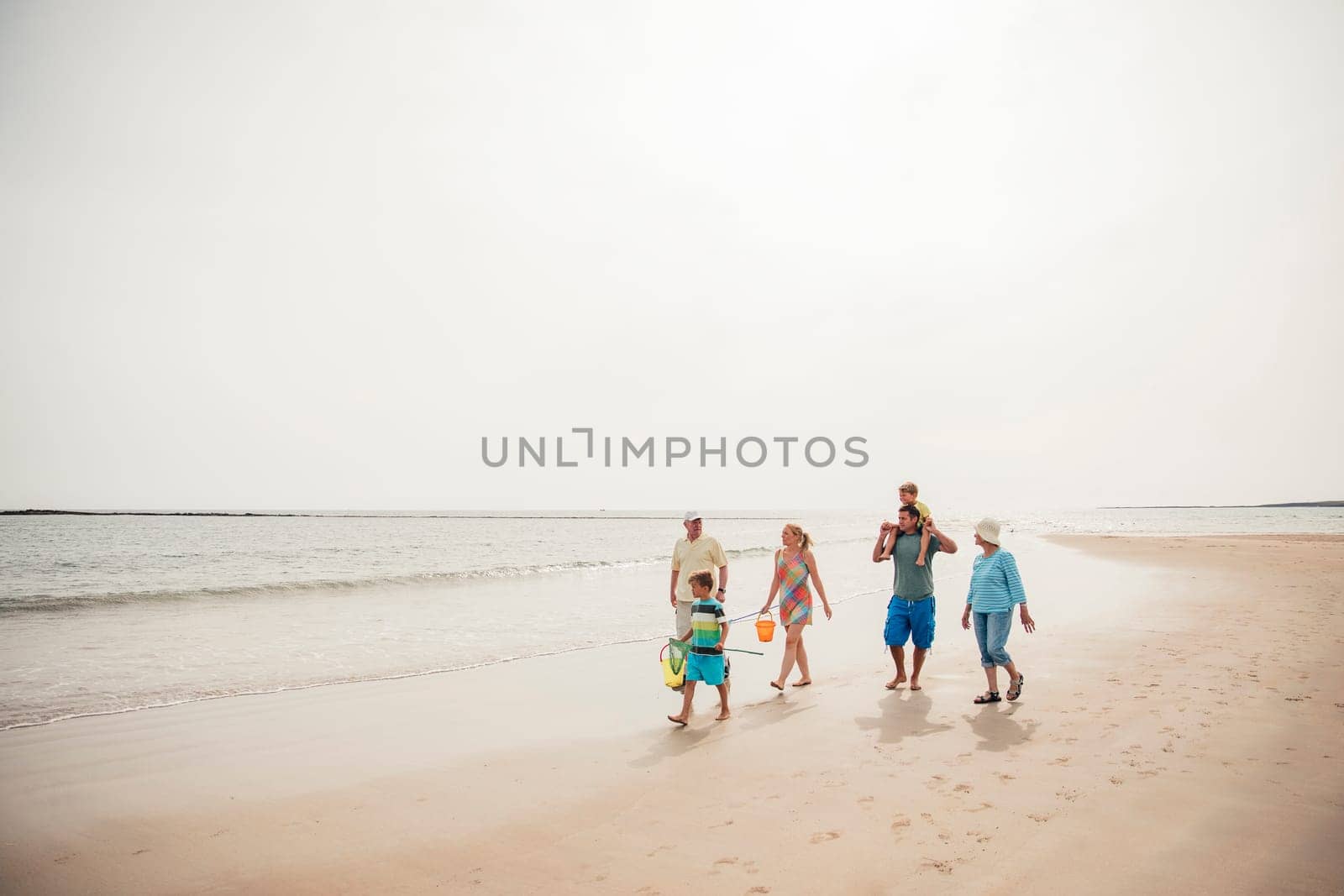 Wide angle view of a family walking along the beach.