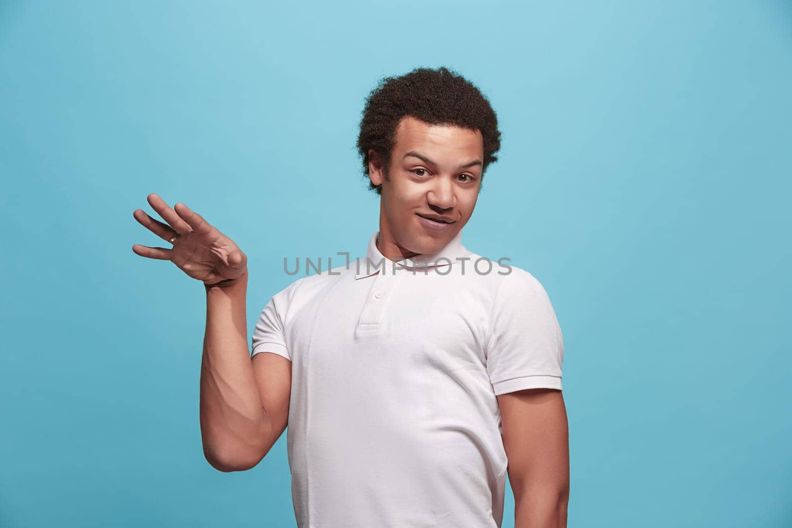 Argue, arguing concept. Beautiful male half-length portrait isolated on blue studio backgroud. Young emotional surprised man looking at camera. Human emotions, facial expression concept. Front view