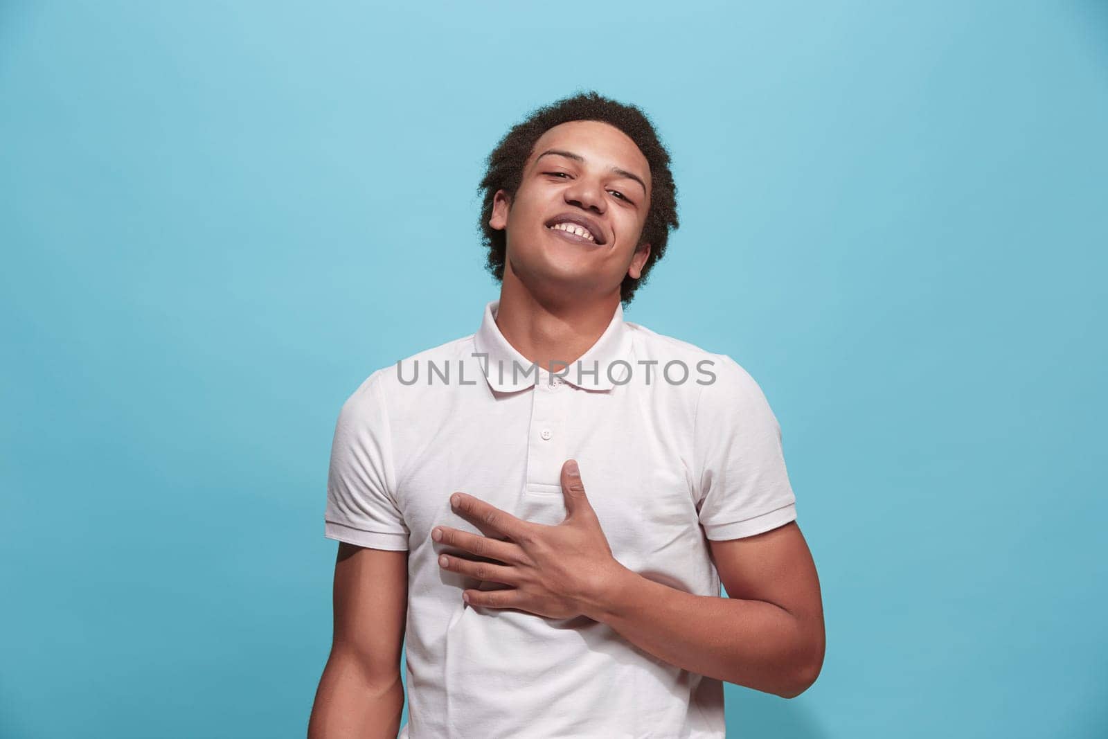 Happy business man standing and smiling isolated on blue studio background. Beautiful male half-length portrait. Young emotional man. The human emotions, facial expression concept. Front view.