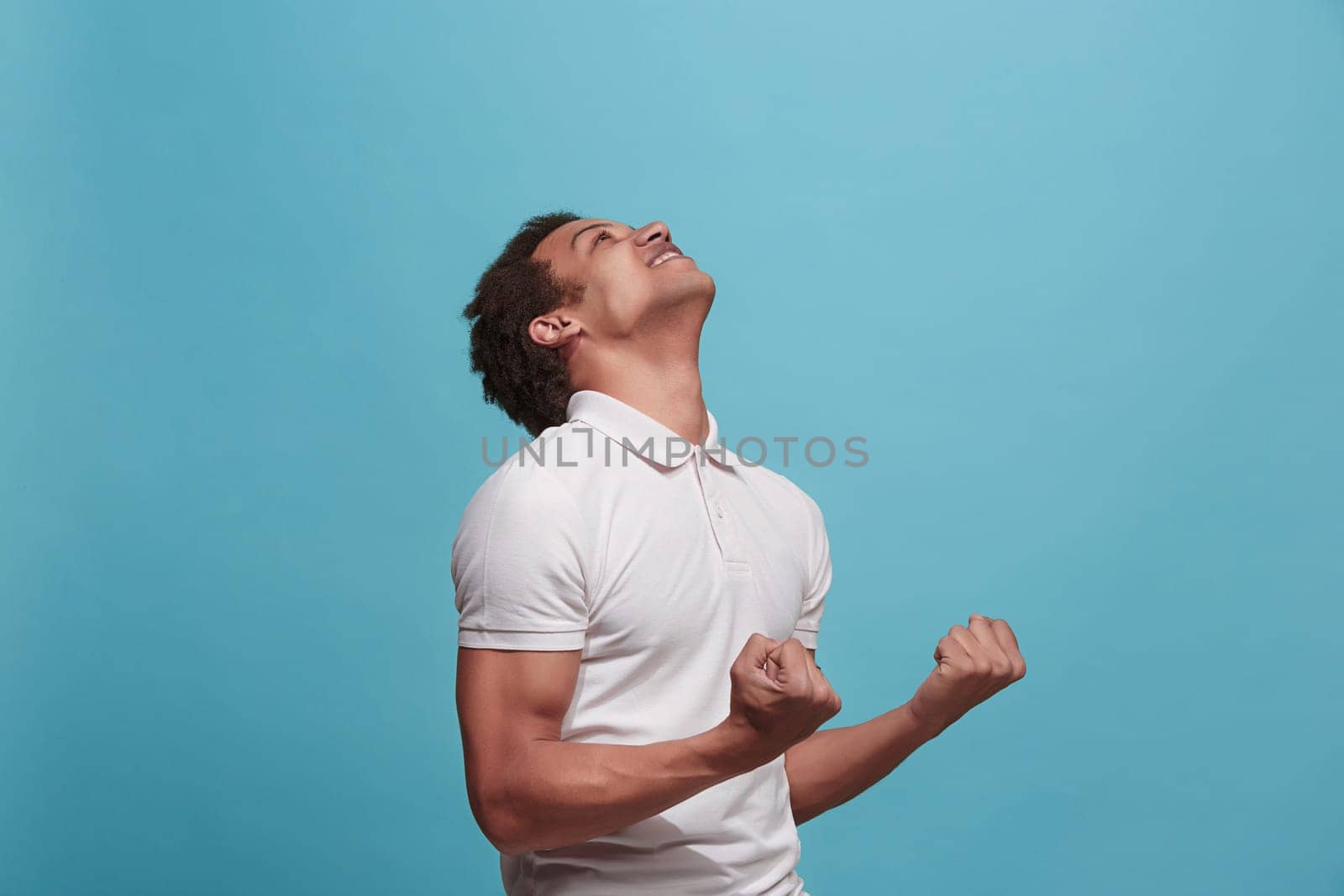 I won. Winning success happy man celebrating being a winner. Dynamic image of caucasian male model on blue studio background. Victory, delight concept. Human facial emotions concept. Trendy colors