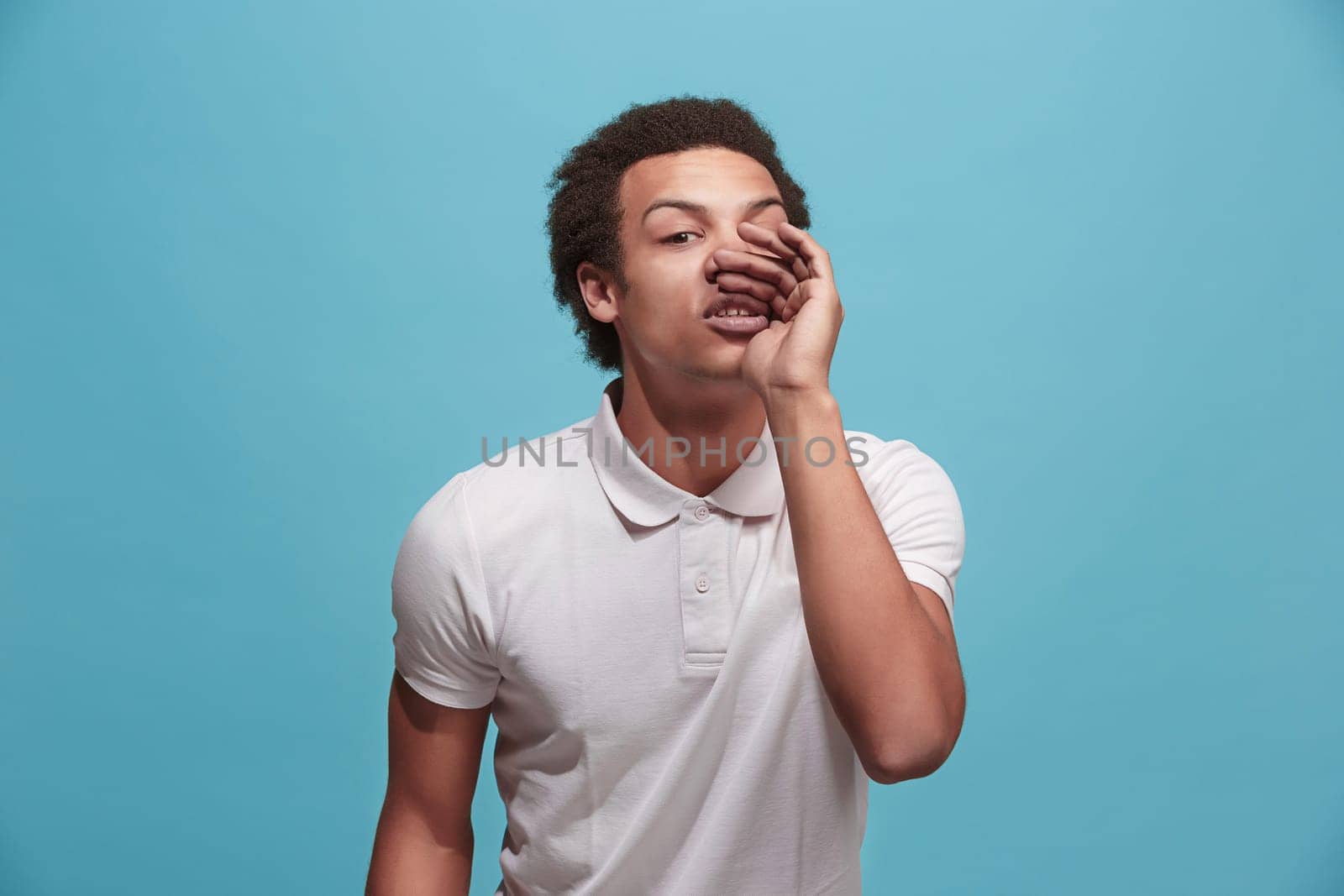 Do not miss. Young casual man shouting. Shout. Crying emotional man screaming on blue studio background. male half-length portrait. Human emotions, facial expression concept. Trendy colors