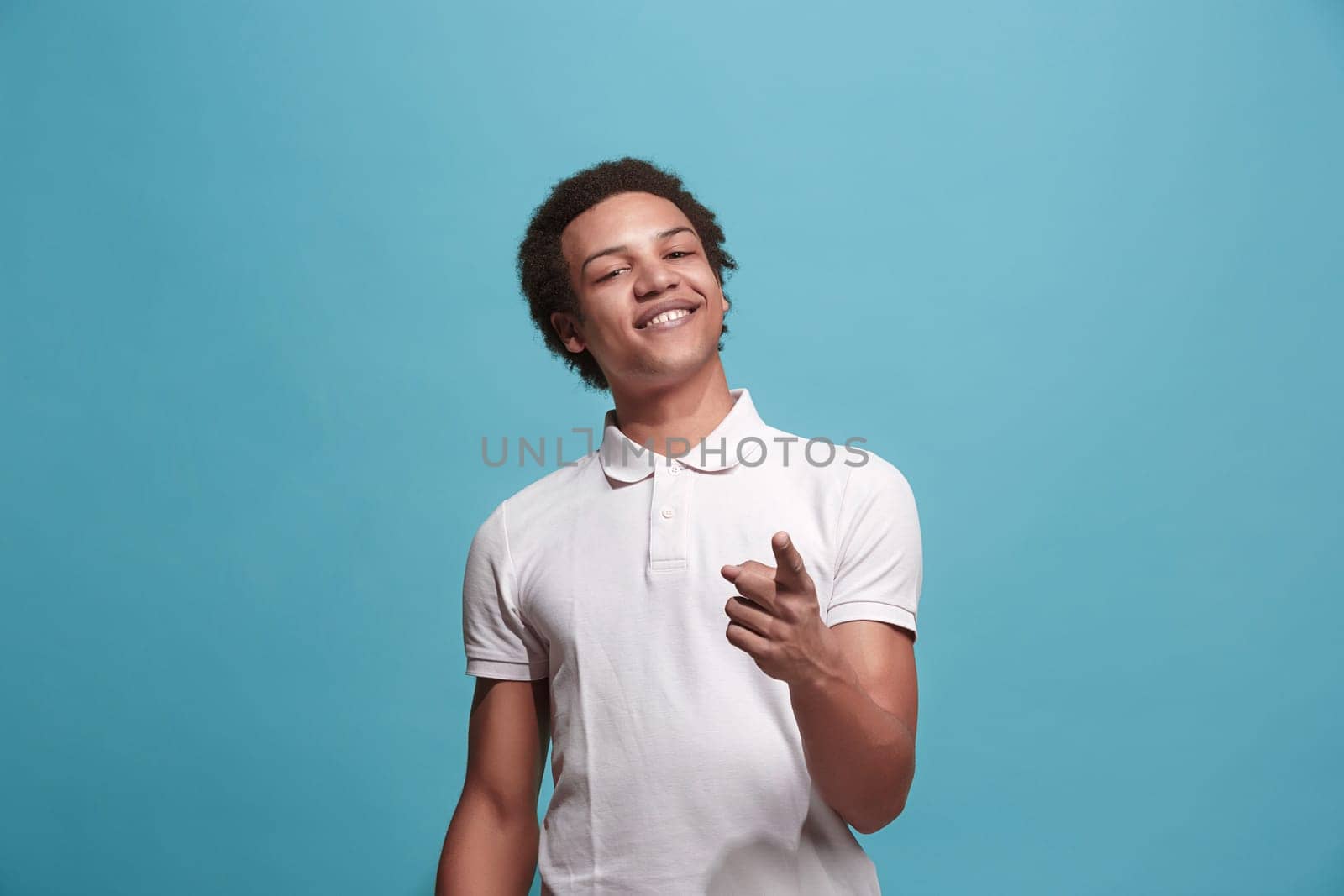 I choose you and order. The smiling business man point you, want you, half length closeup portrait on blue studio background. The human emotions, facial expression concept. Front view. Trendy colors