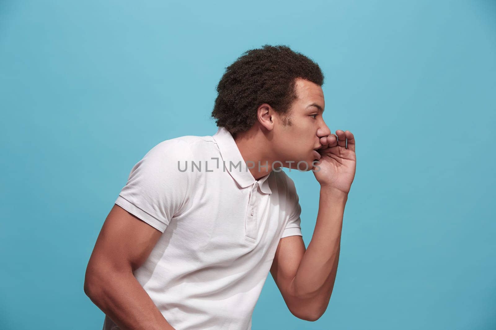 Do not miss. Young casual man shouting. Shout. Crying emotional man screaming on blue studio background. male half-length portrait. Human emotions, facial expression concept. Trendy colors