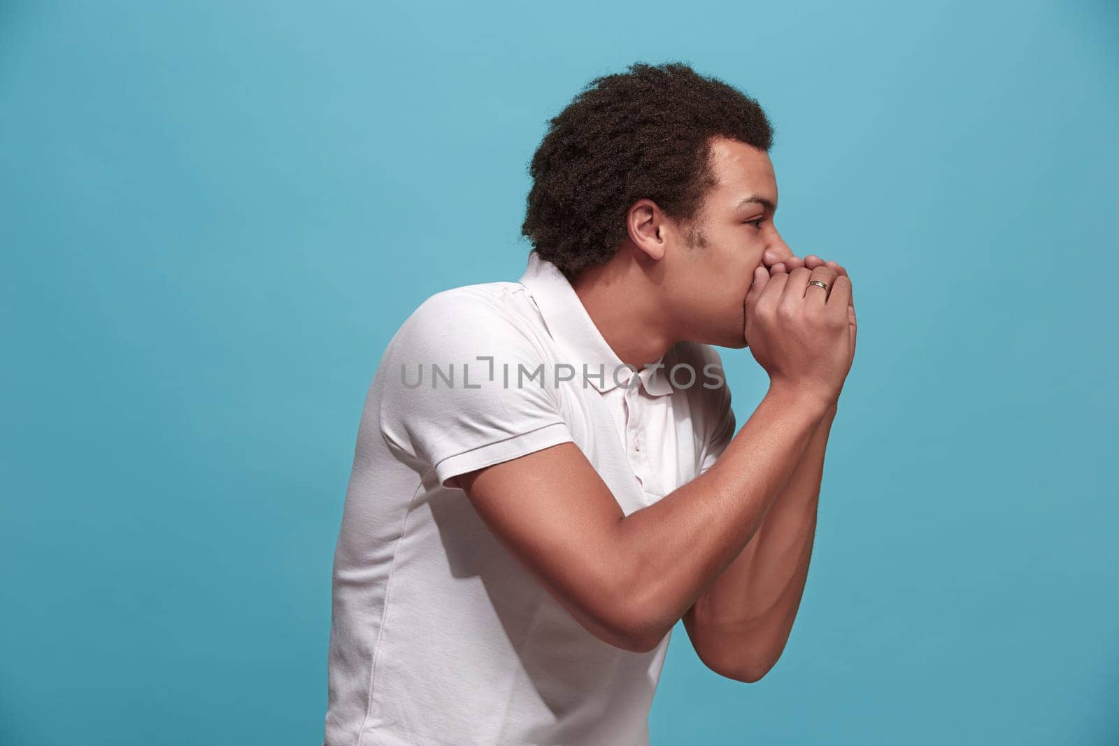 Do not miss. Young casual man shouting. Shout. Crying emotional man screaming on blue studio background. male half-length portrait. Human emotions, facial expression concept. Trendy colors