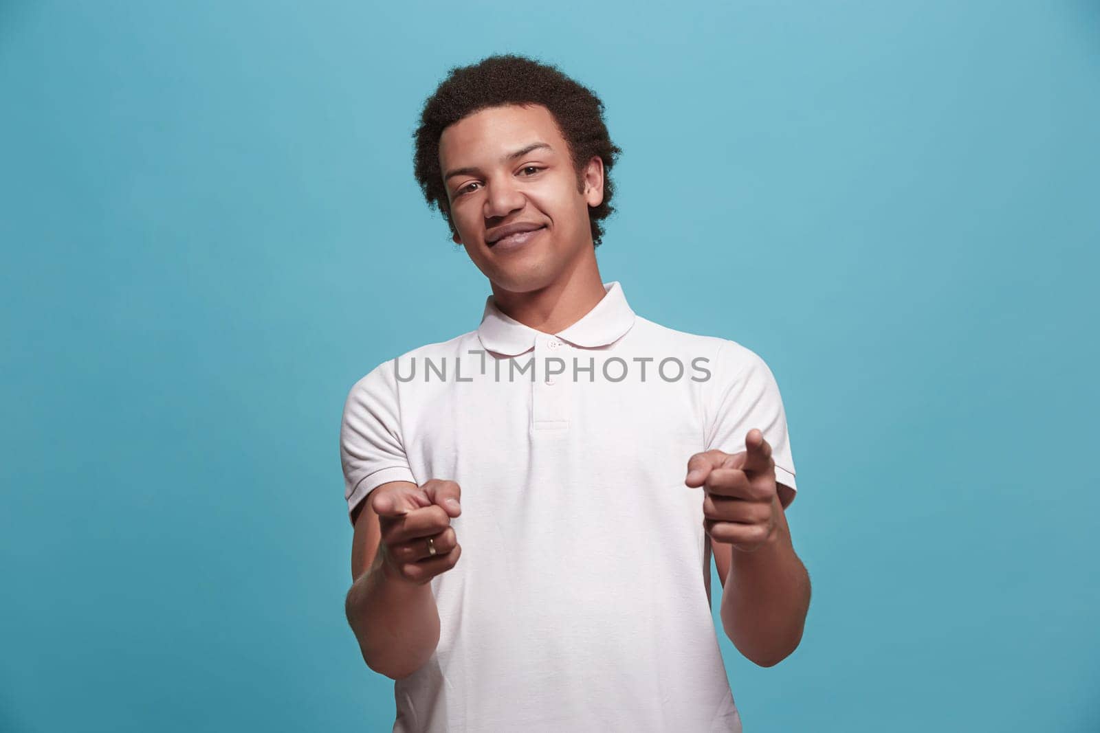 I choose you and order. The smiling business man point you, want you, half length closeup portrait on blue studio background. The human emotions, facial expression concept. Front view. Trendy colors