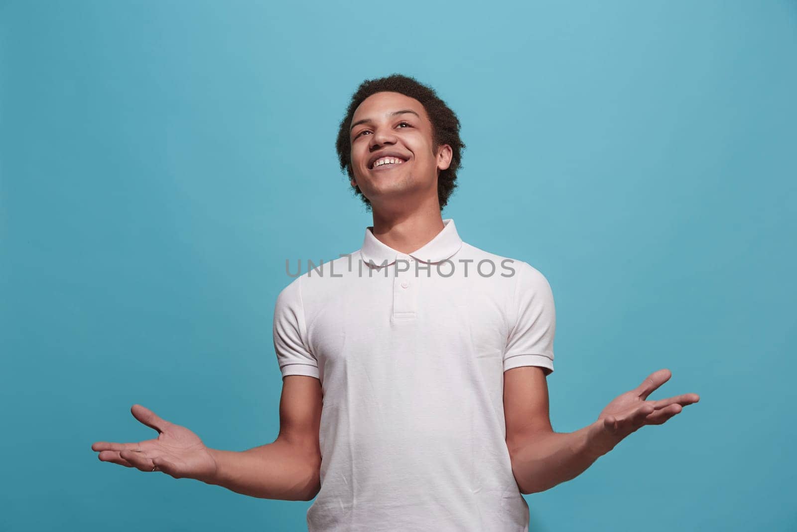 Happy business man standing and smiling isolated on blue studio background. Beautiful male half-length portrait. Young emotional man. The human emotions, facial expression concept. Front view.