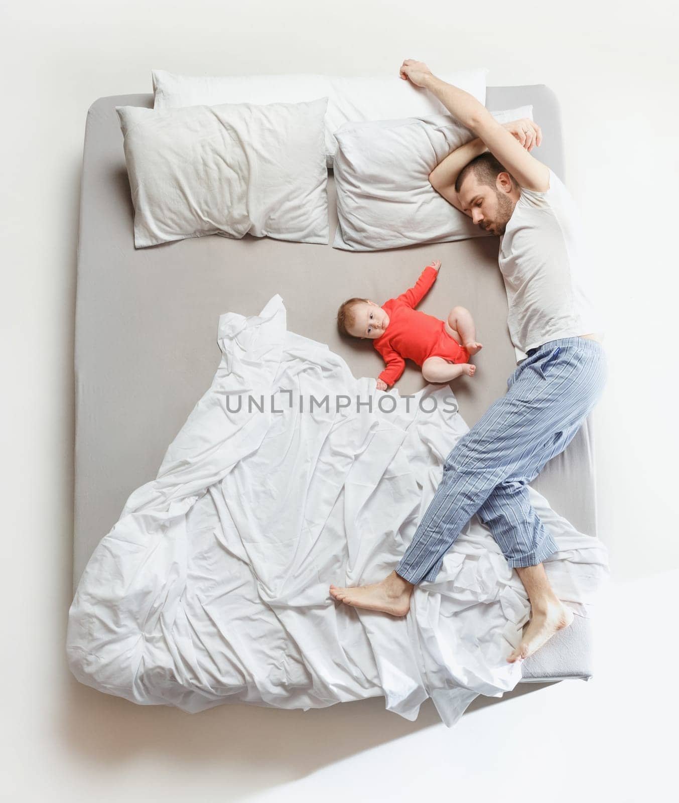 Top view of happy funny family with one newborn child in bedroom. Enjoying being together. Happy family in bed. Top view. Emotions concept. Morning after sleep. Family lifestyle. happy parents concept