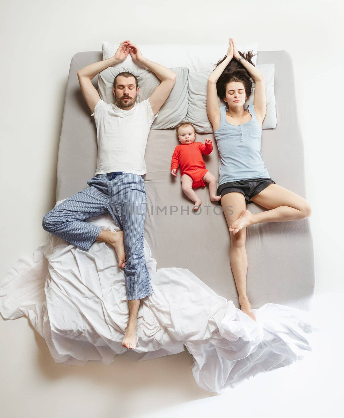 Top view of happy funny family with one newborn child in bedroom. Enjoying being together. Happy family in bed. Top view. Emotions concept. Morning after sleep. Family lifestyle. happy parents concept