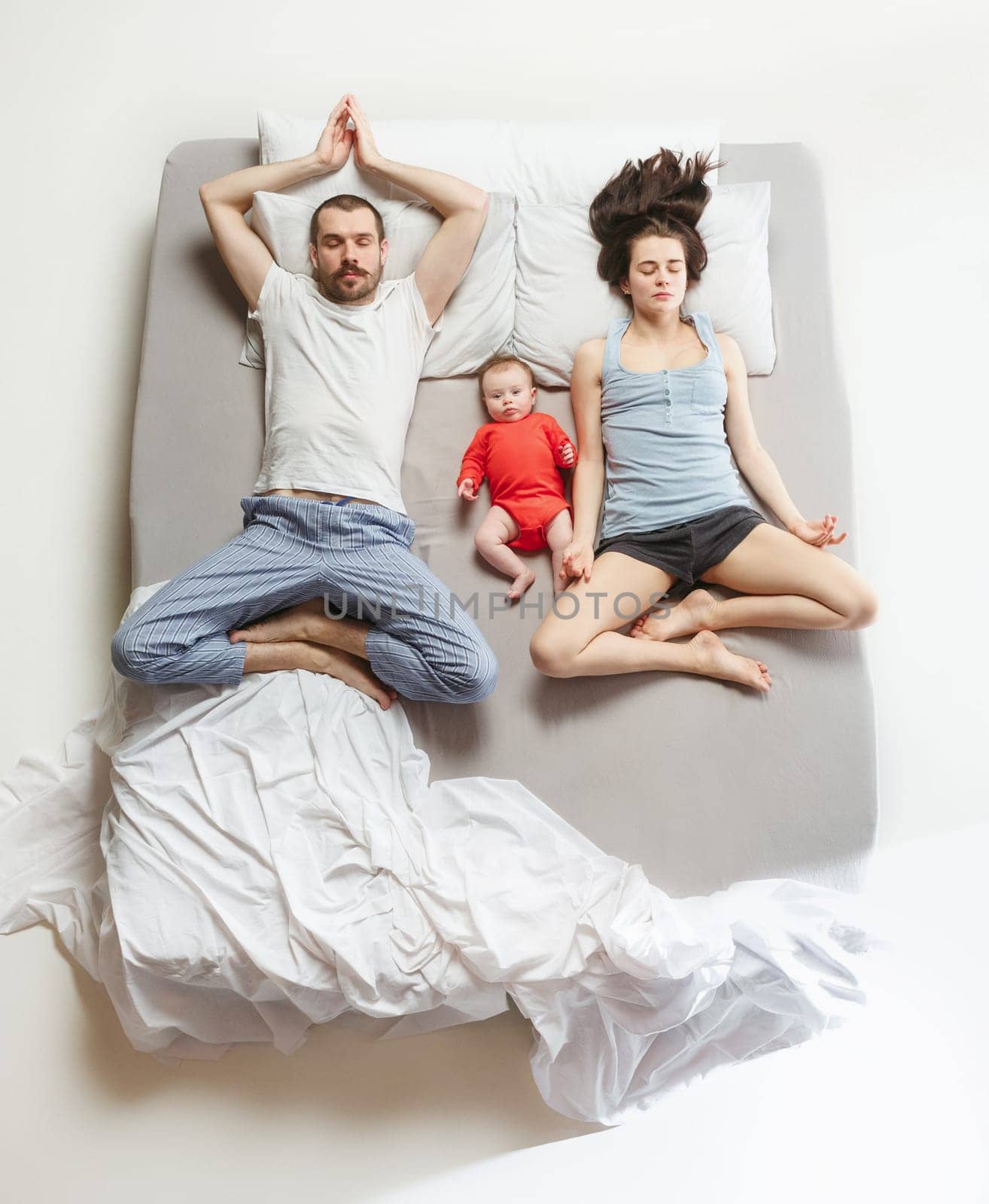 Top view of happy funny family with one newborn child in bedroom. Enjoying being together. Happy family in bed. Top view. Emotions concept. Morning after sleep. Family lifestyle. happy parents concept