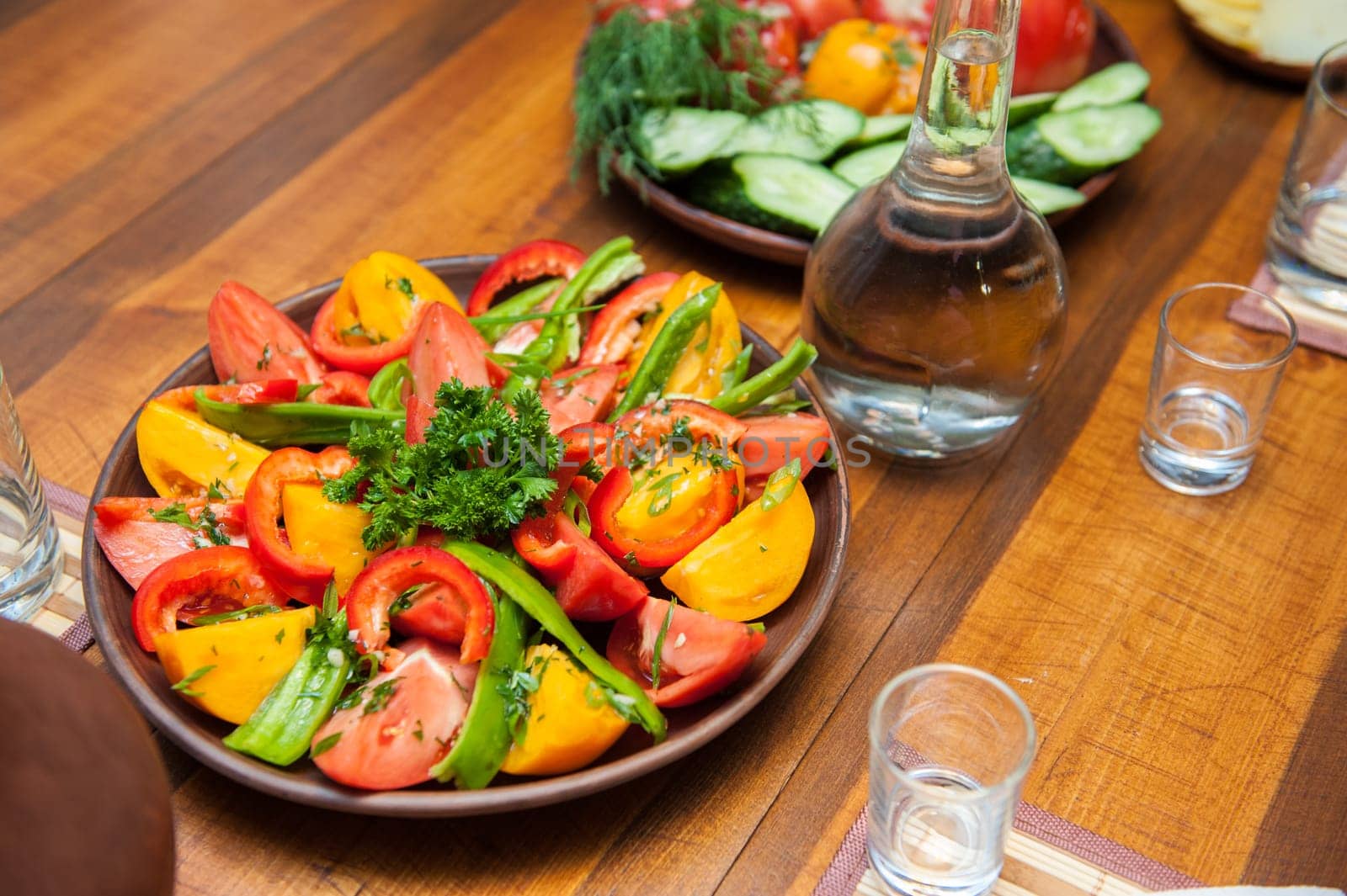 Multi-colored fresh cutted vegetables on a wooden plate