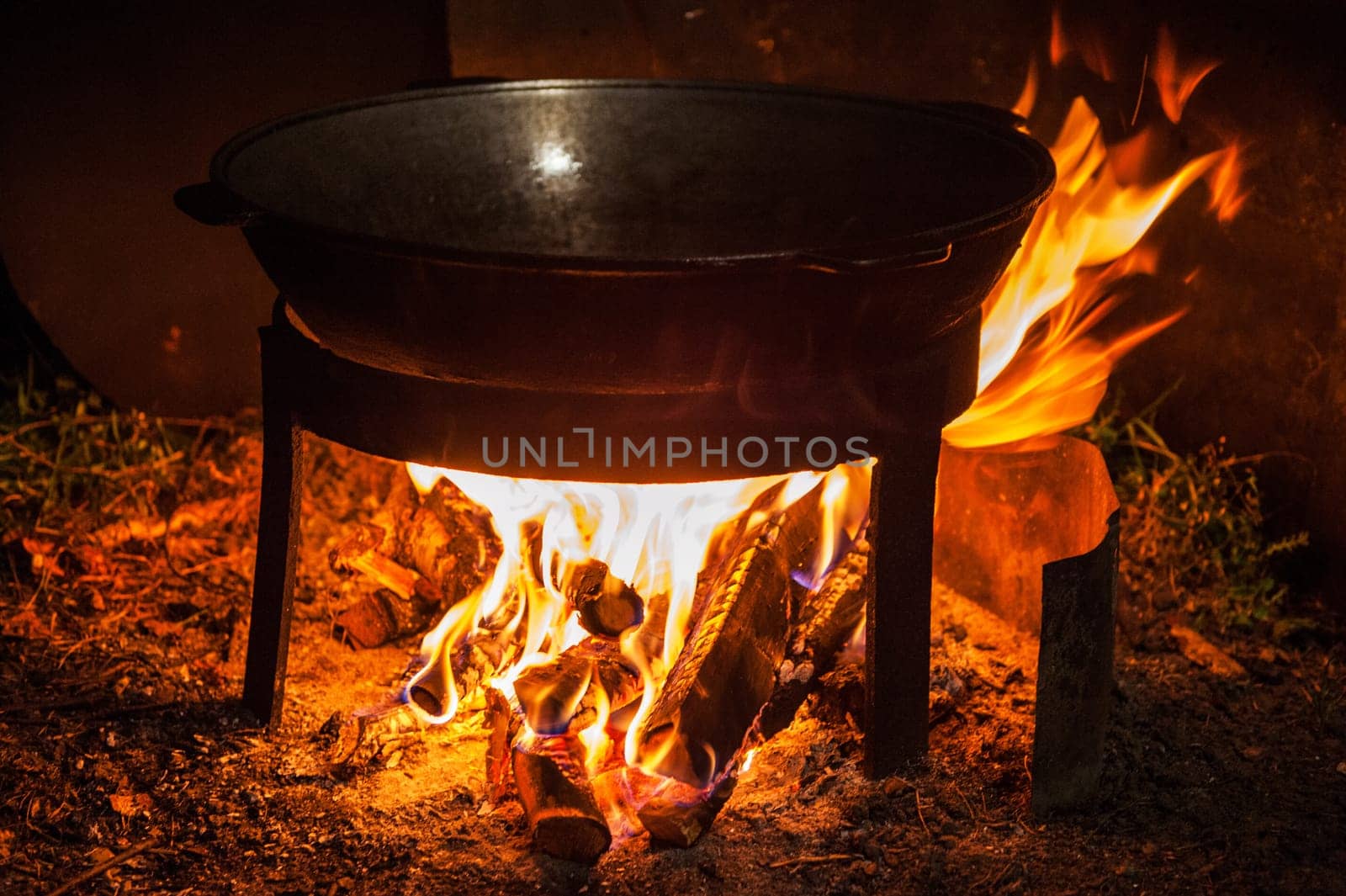 Camping fire and kettle with frying fish