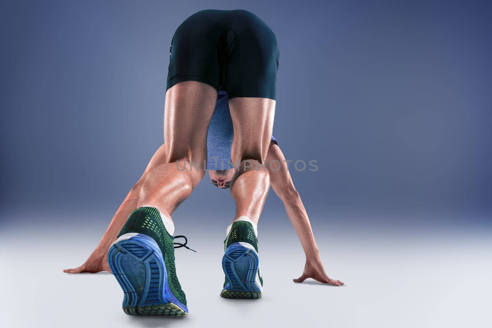 The studio shot of high jump athlete is in action on blue background