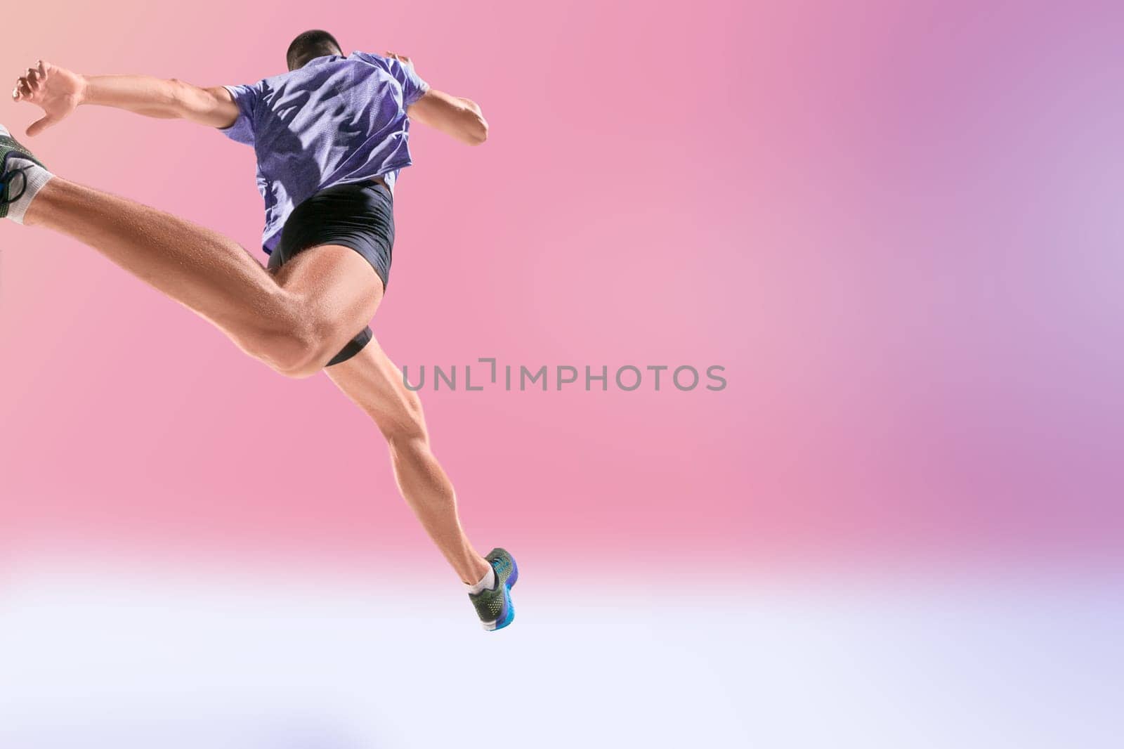 The studio shot of high jump athlete is in action on pink background