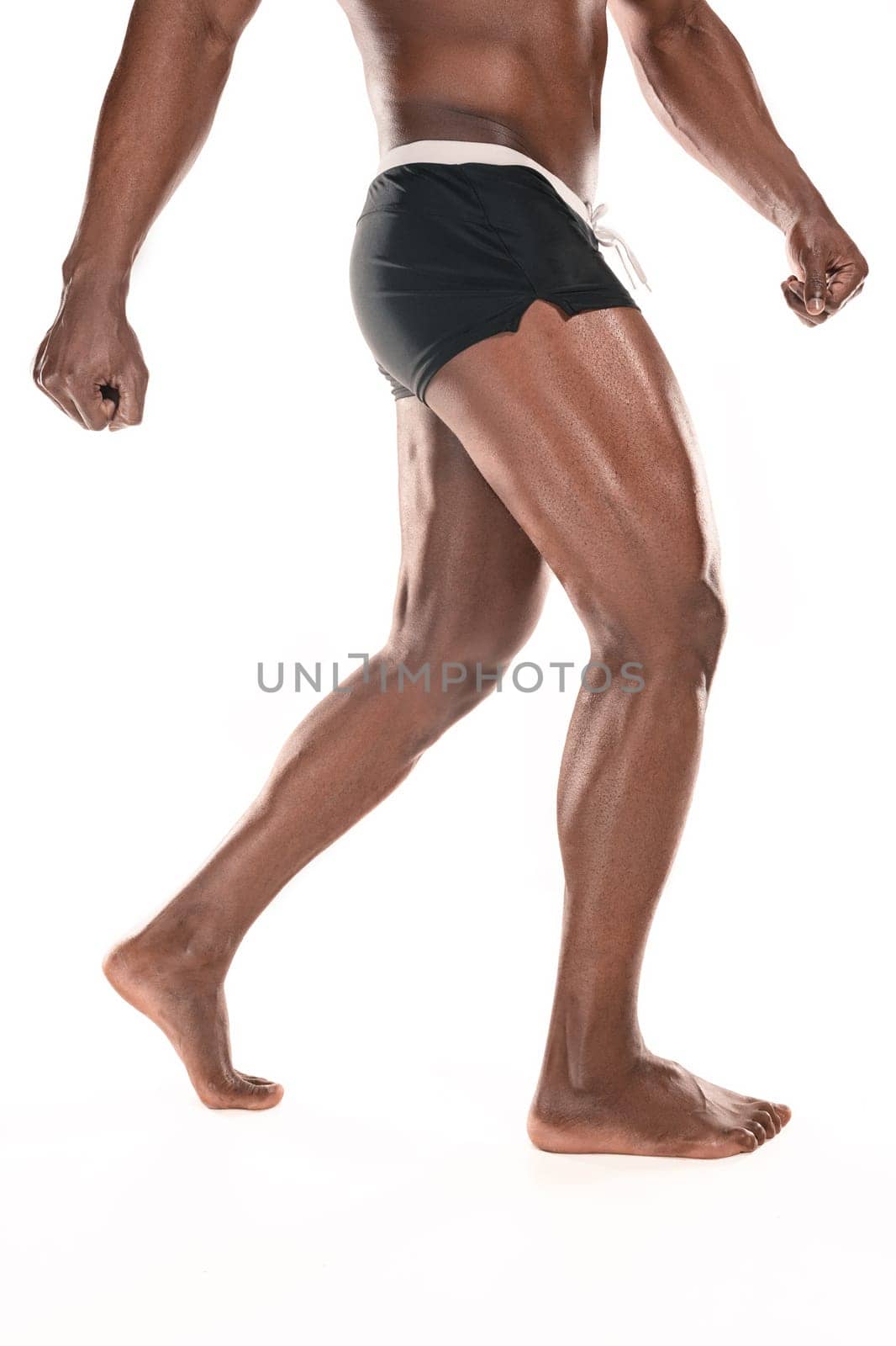 Fit young man with beautiful torso, isolated on white background. The naked torso of African American man posing at studio. The muscular body, fitness, sports, healthy lifestyle and bodybuilder concept.