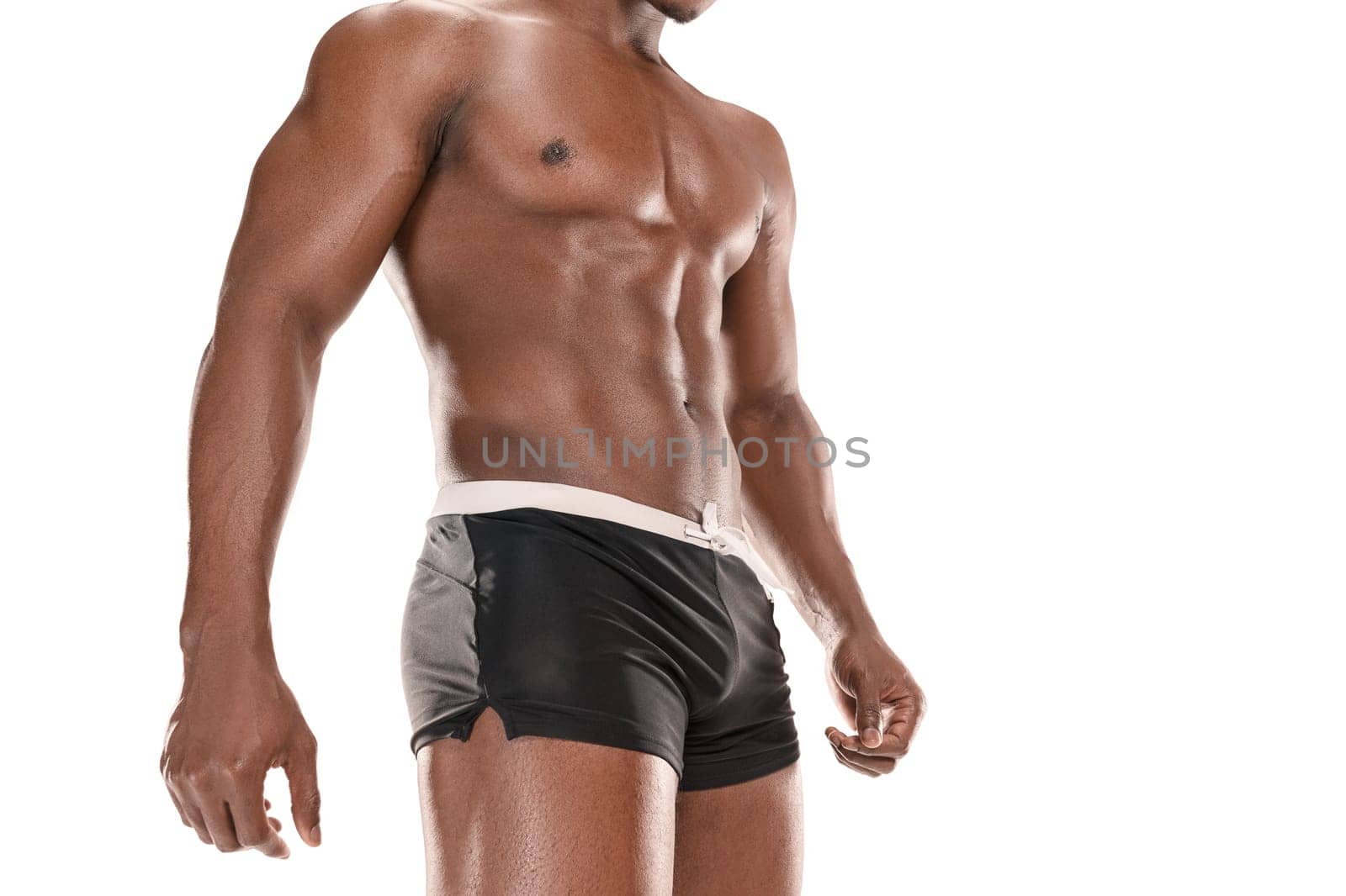 Fit young man with beautiful torso, isolated on white background. The naked torso of African American man posing at studio. The muscular body, fitness, sports, healthy lifestyle and bodybuilder concept.
