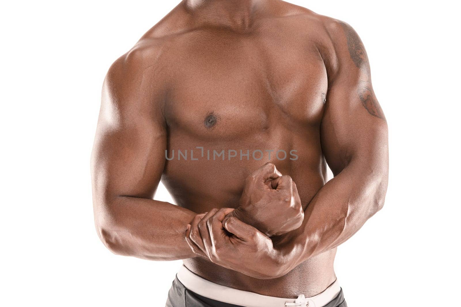 Fit young man with beautiful torso, isolated on white background. The naked torso of African American man posing at studio. The muscular body, fitness, sports, healthy lifestyle and bodybuilder concept.