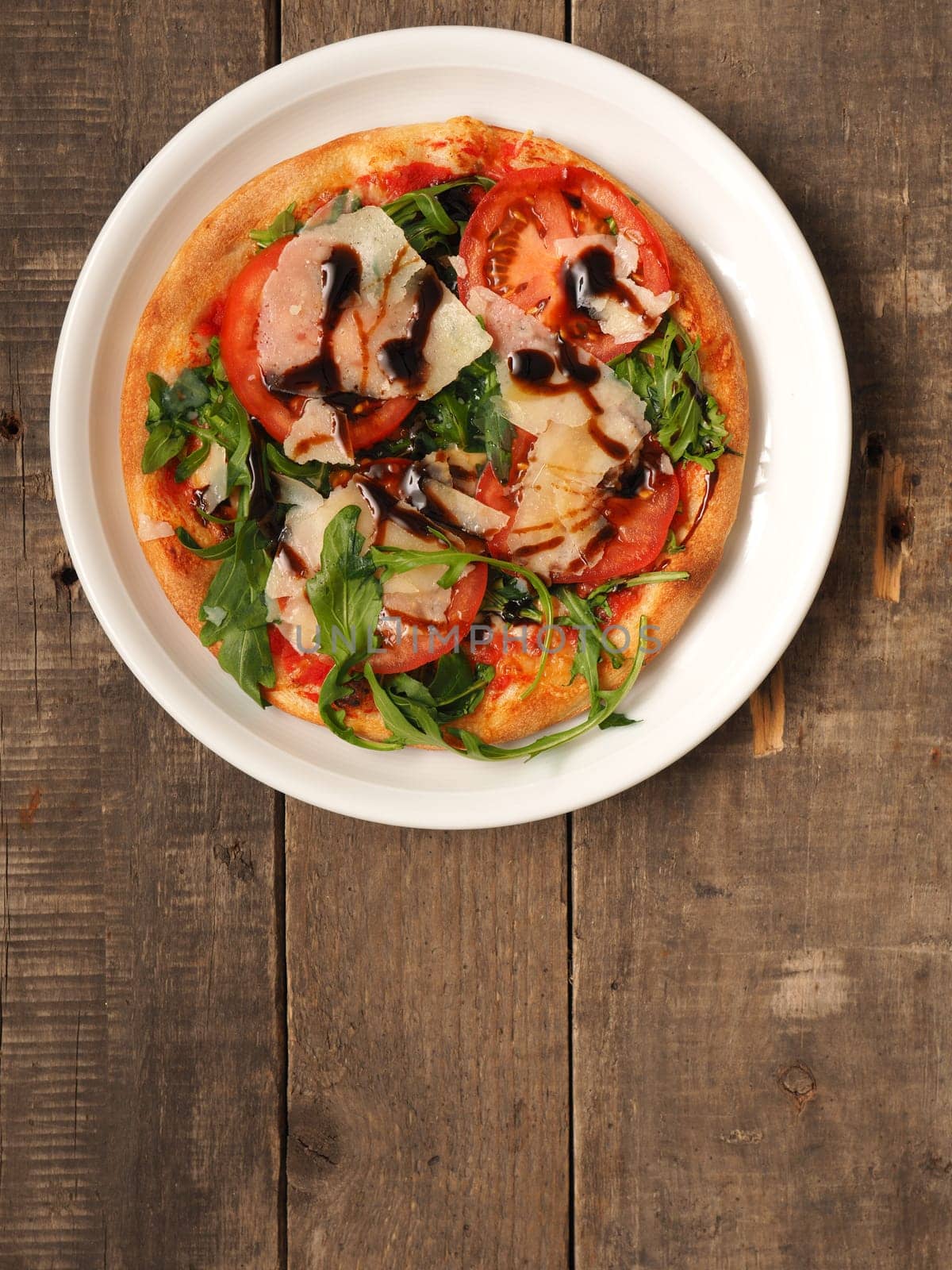 Tasty pizza on a rustic wooden kitchen table, view from above with space for text