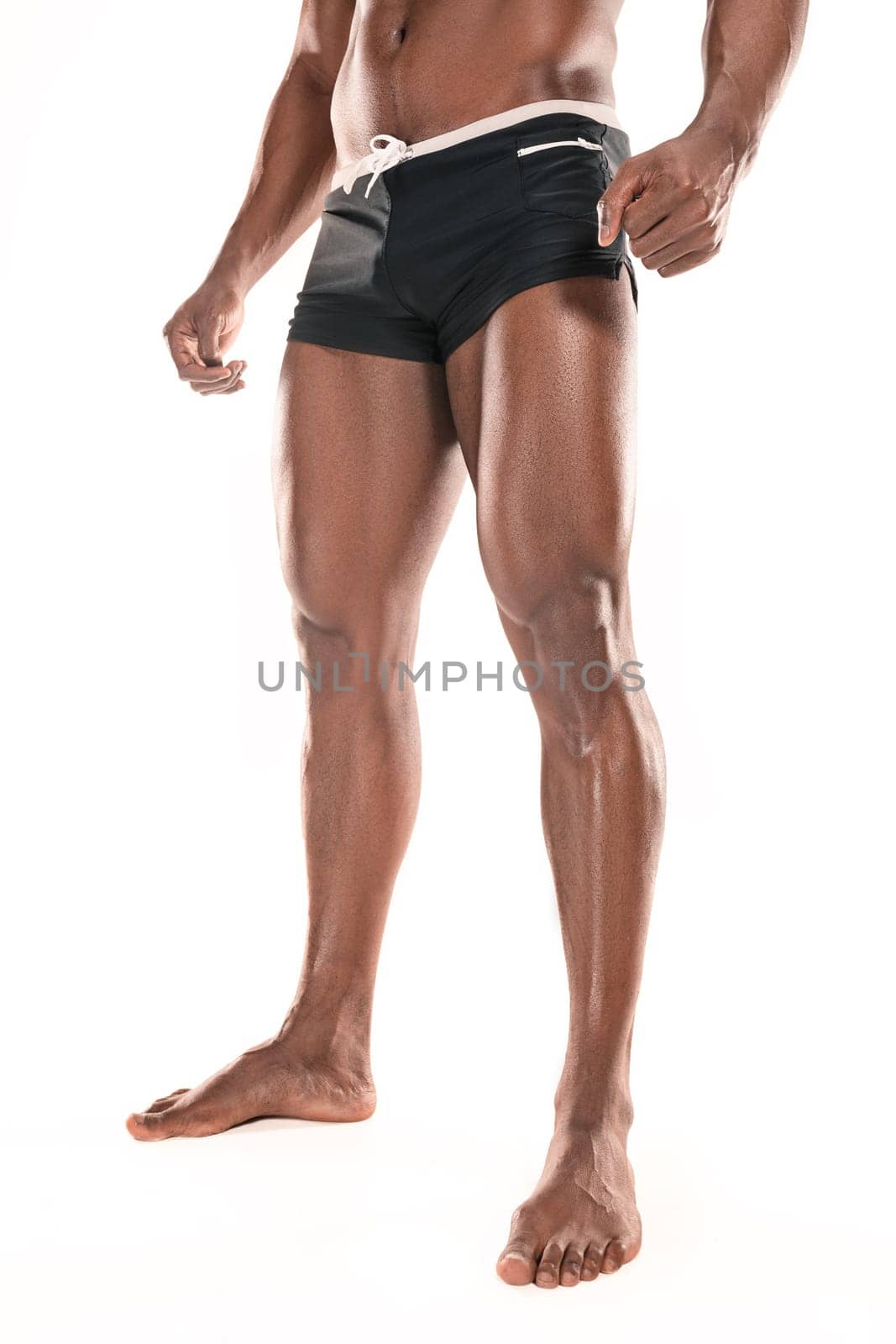 Fit young man with beautiful torso, isolated on white background. The naked torso of African American man posing at studio. The muscular body, fitness, sports, healthy lifestyle and bodybuilder concept.