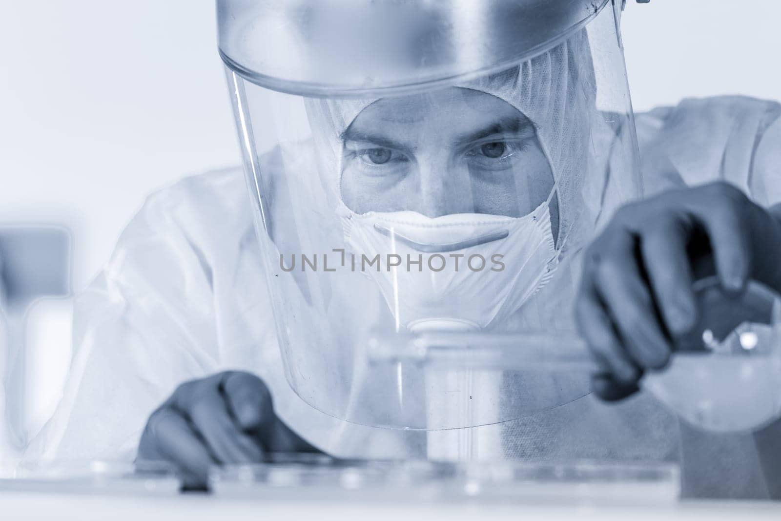 Life scientist researching in bio hazard laboratory. Focused life science professional working on experiment in high protection degree work laboratory. Healthcare and biotechnology.