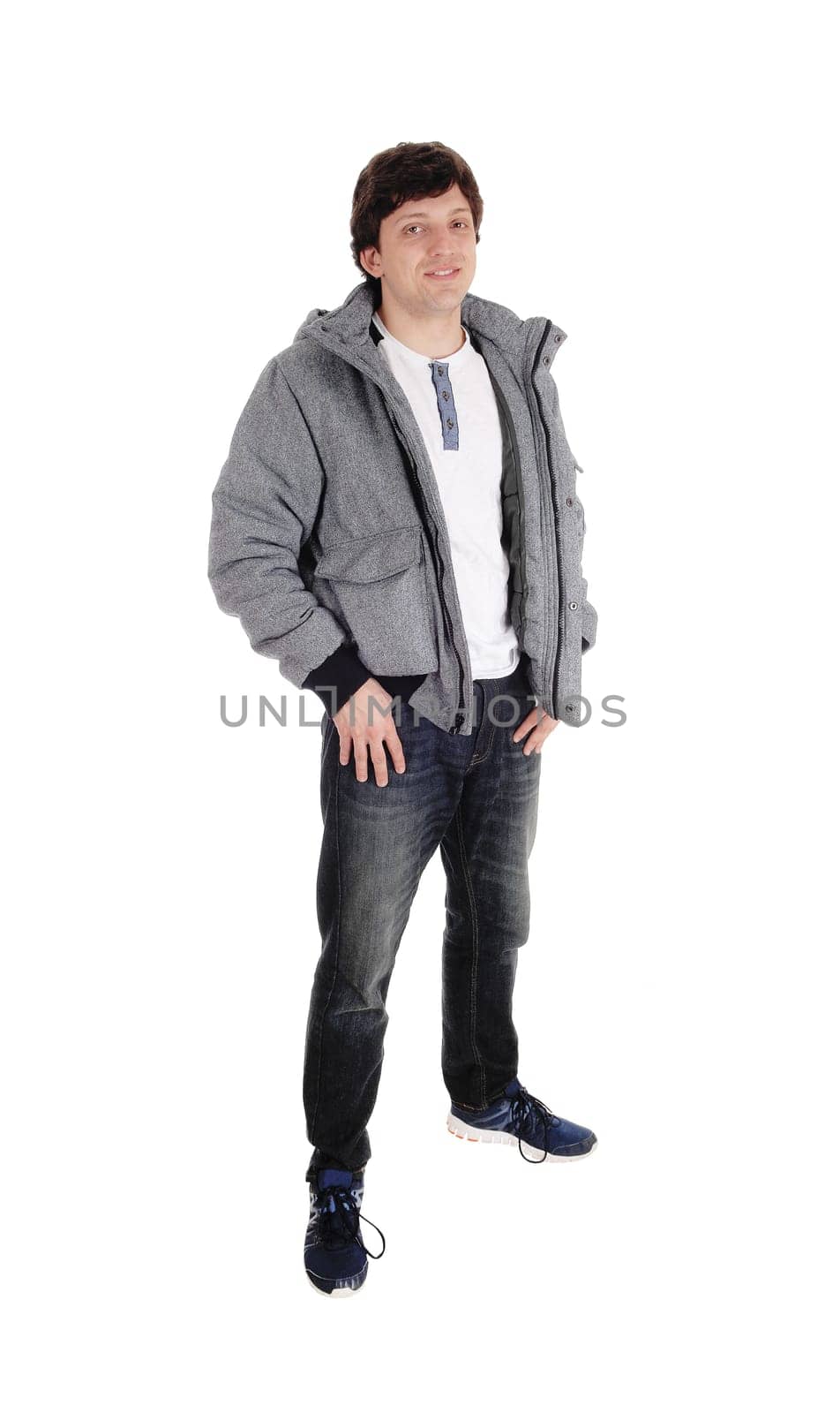 A Caucasian handsome young man standing in a gray jacket sneakers and jeans.isolated for white background.