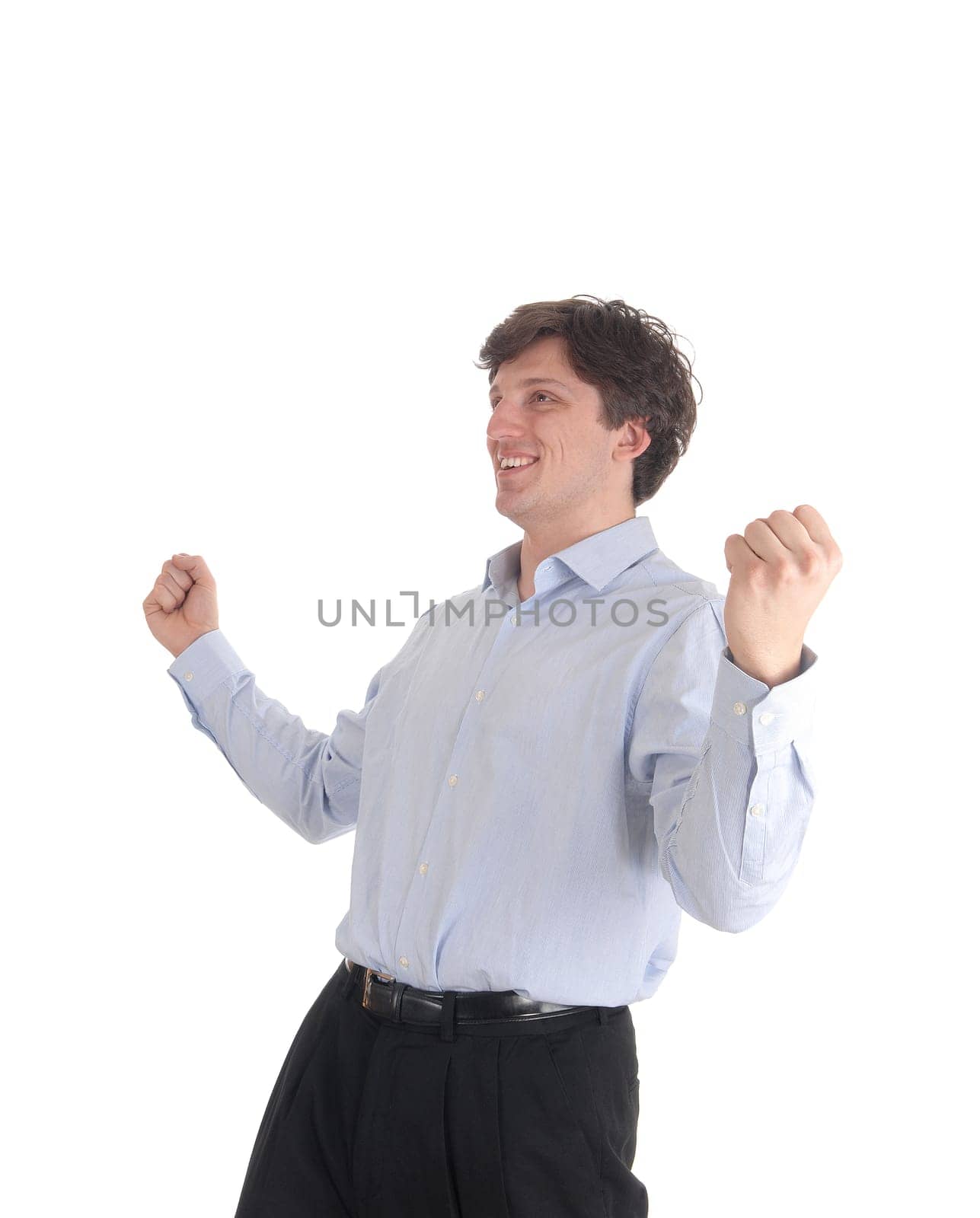 A handsome young man standing with his arms raised and smiling for.excitement, isolated foe white background.