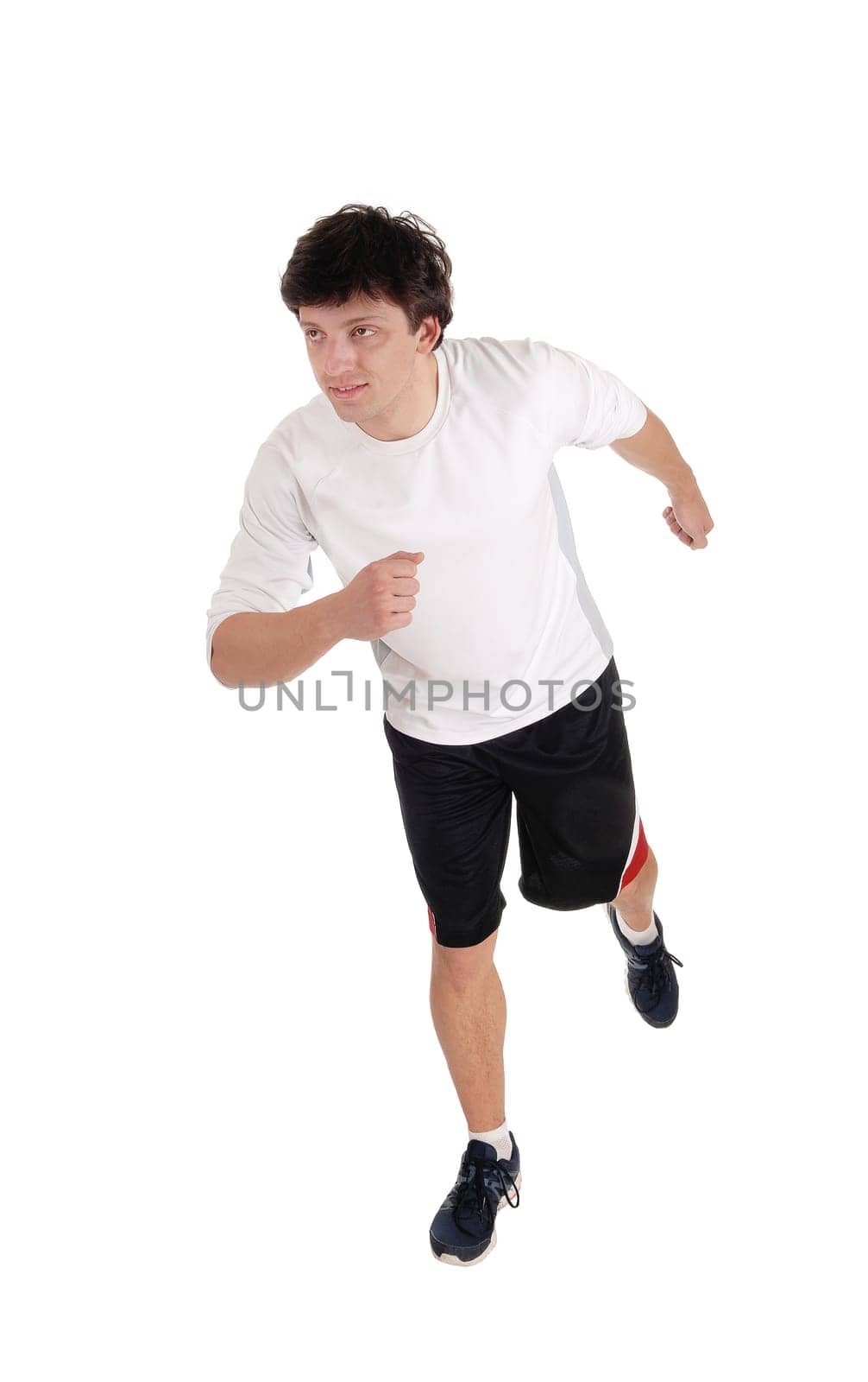 An handsome young man running in the studio in exercise outfit and running.shoes, isolated for white background.