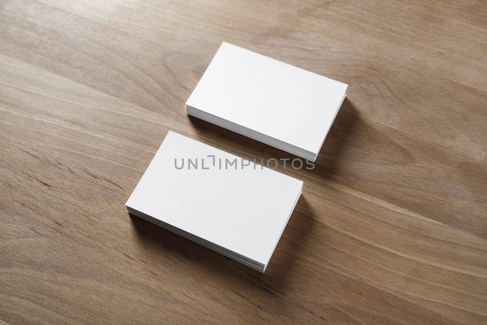 Mockup of two horizontal business cards stacks on wood background.