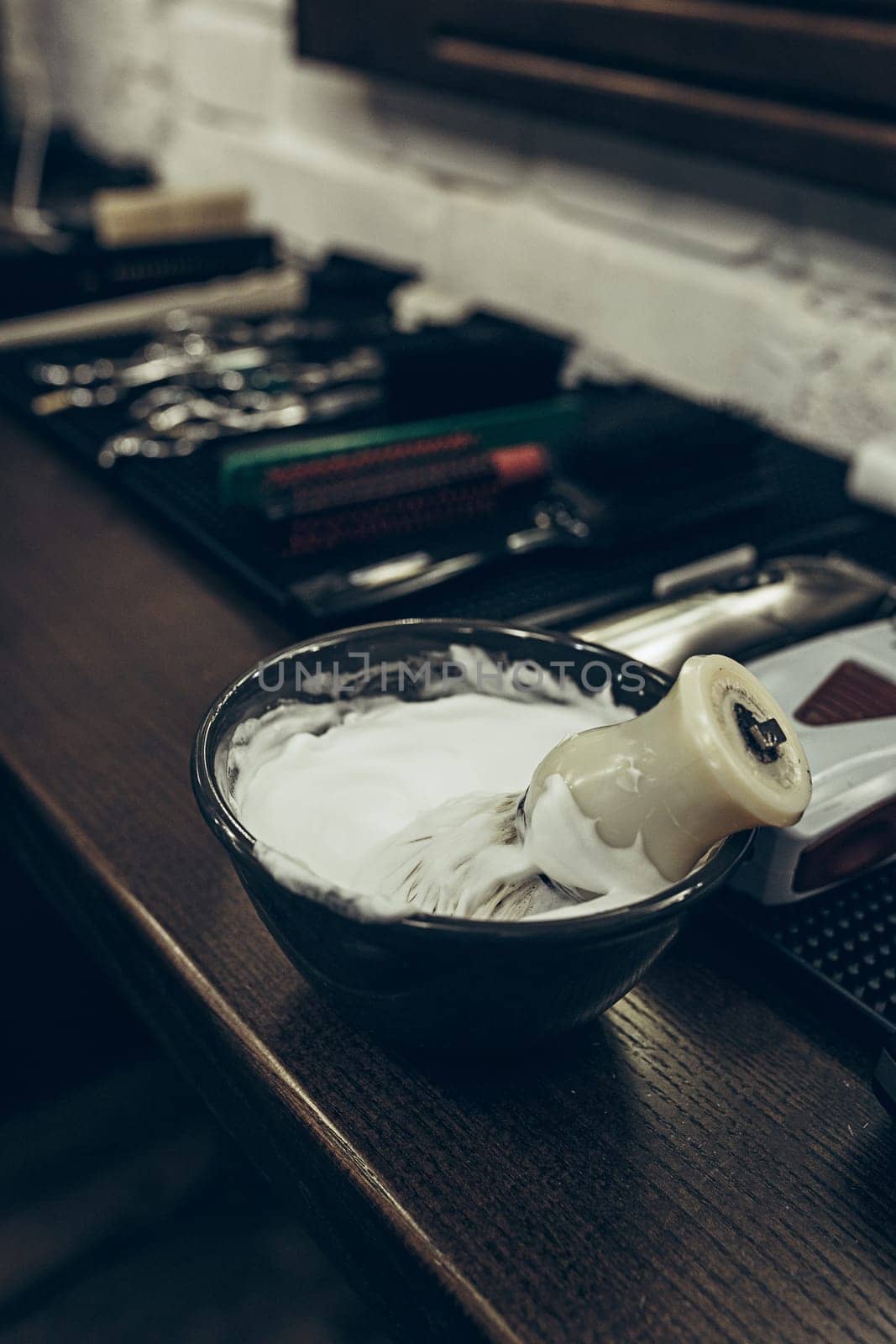Barber shop tools on the table. Close up view shaving foam. Barber shop concept. Shaving machine, comb, scissors and different items on the table in the barber shop.
