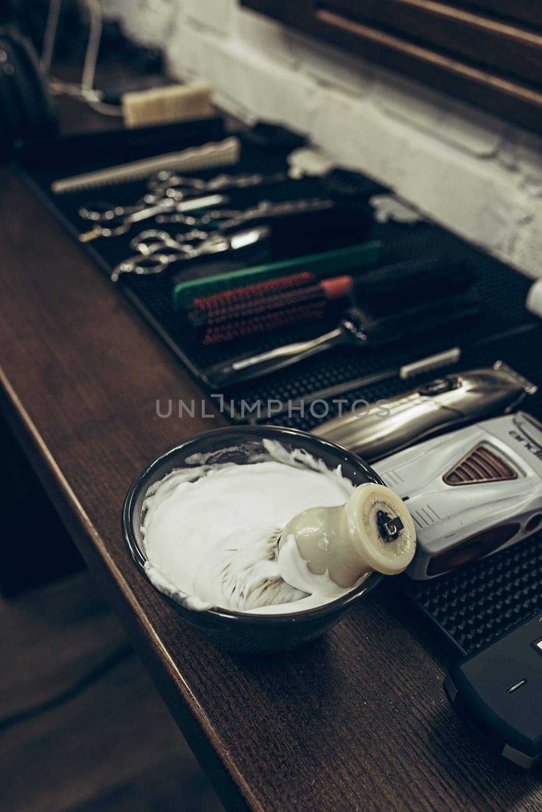 Barber shop tools on the table. Close up view shaving foam. Barber shop concept. Shaving machine, comb, scissors and different items on the table in the barber shop.