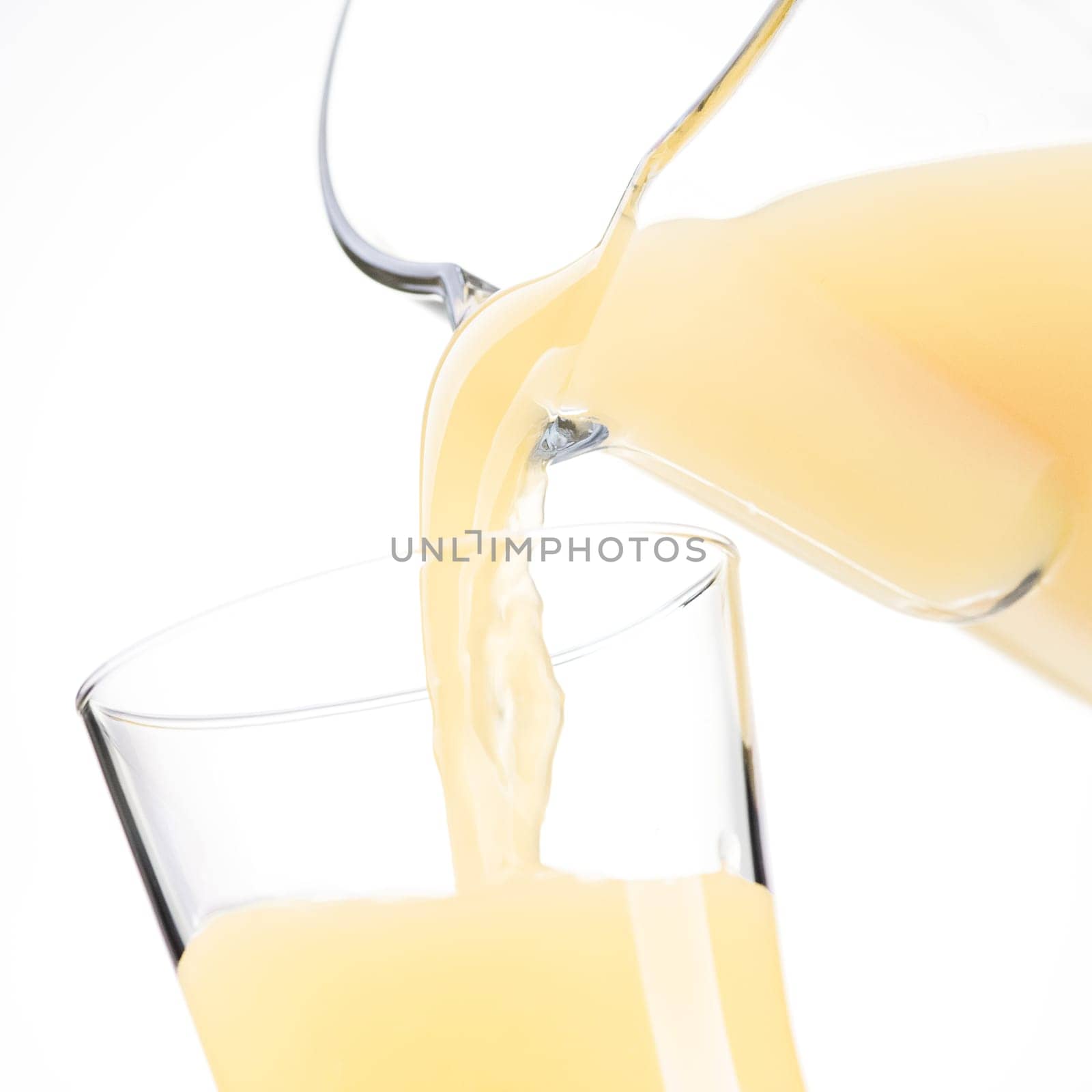 Pouring refreshing apple or lemon juice in a glass, healthy drinks concept