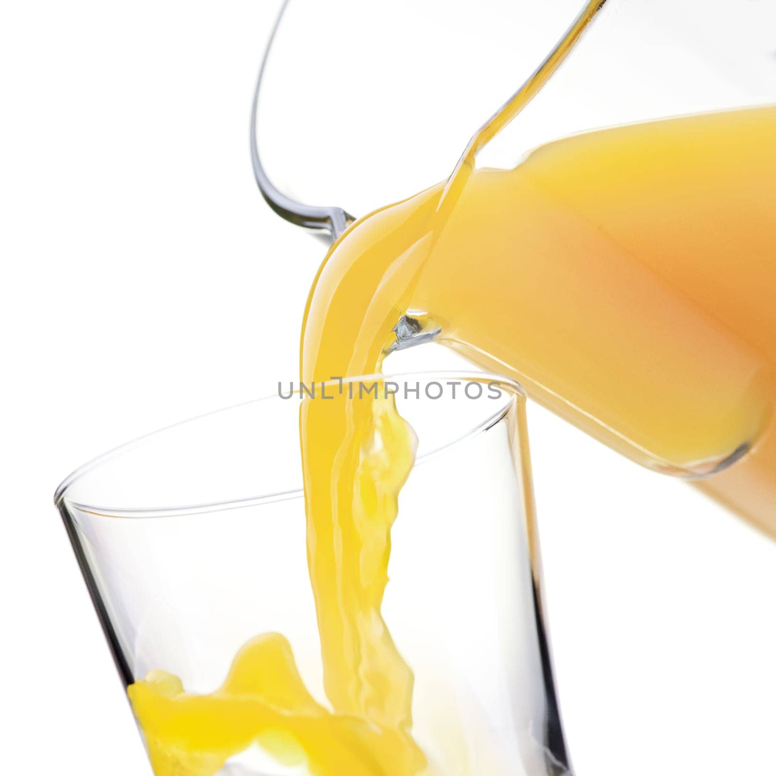 Pouring refreshing orange or pineapple yellow juice in a glass, healthy drinks concept