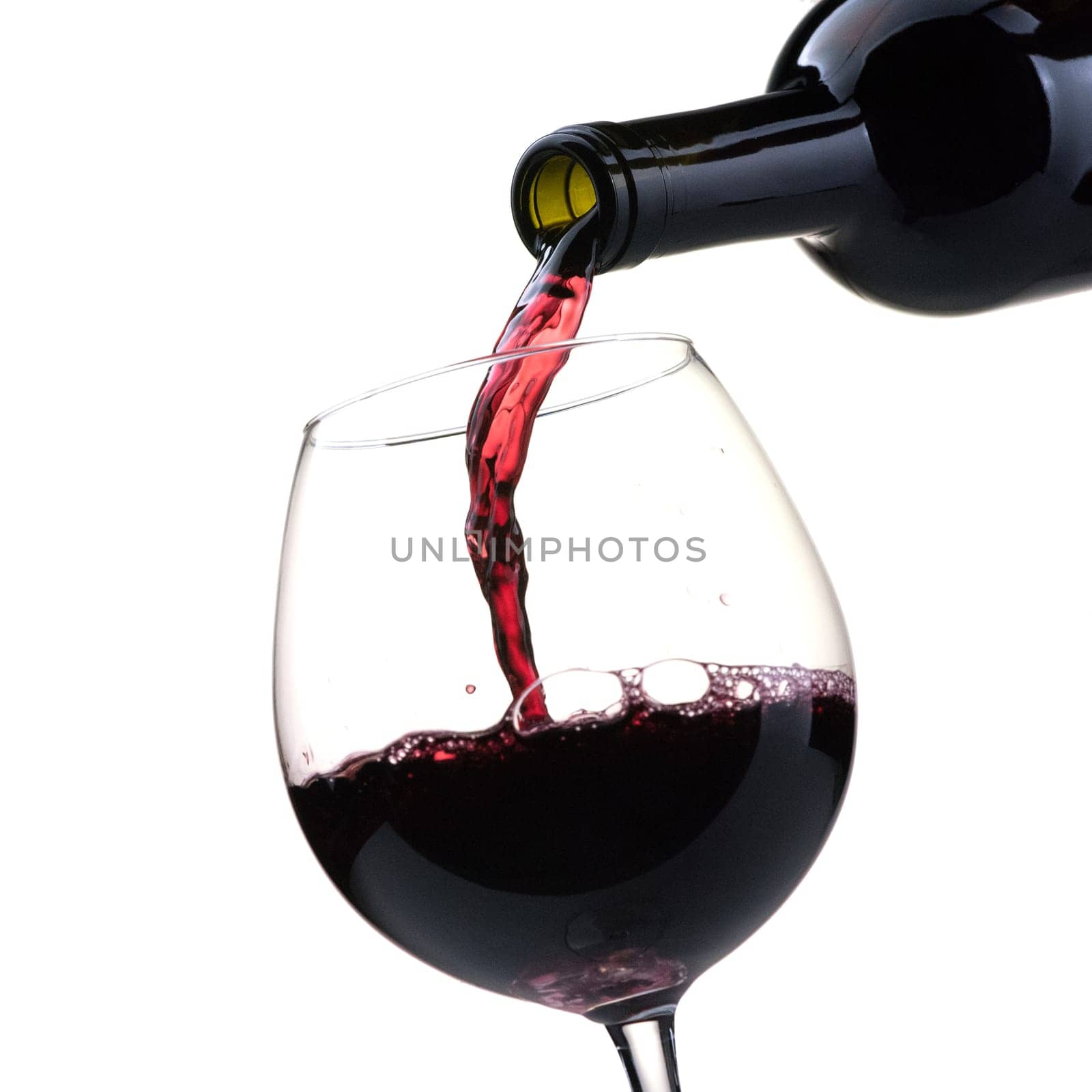 Pouring red wine from a bottle into a wineglass: wine tasting and celebration