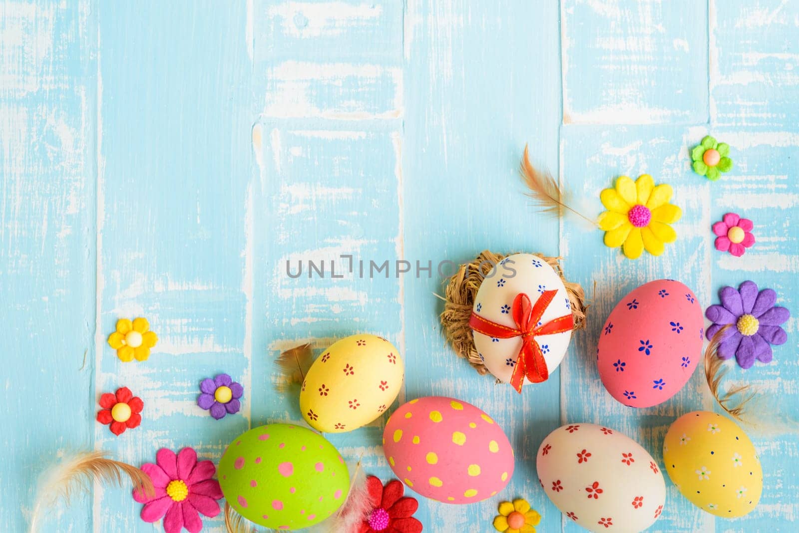 Happy easter! Colorful of Easter eggs in nest on pastel color bright green and white wooden background.