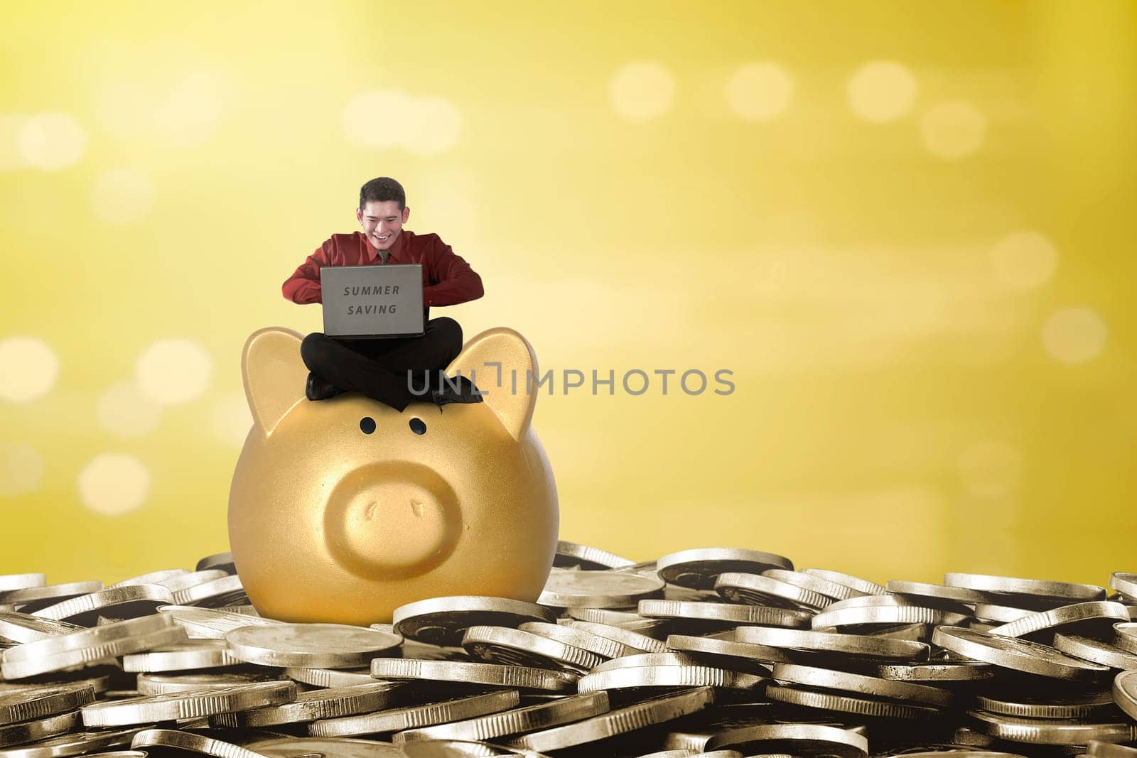 Happy asian businessman using laptop above piggy bank. Summer saving concept